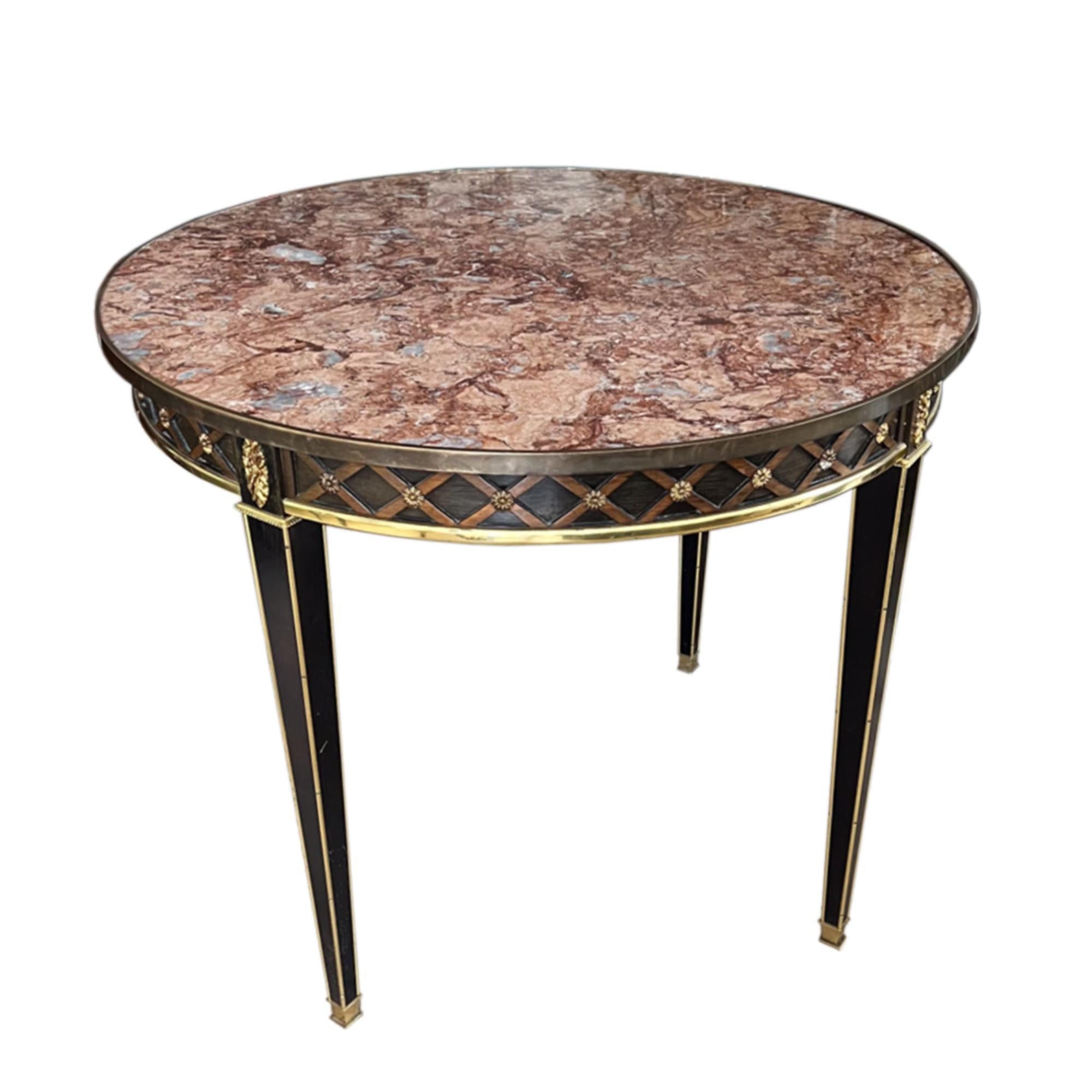 Dieser äußerst dekorative Mitteltisch wurde in den 1930er Jahren in Frankreich nach einem neoklassischen Entwurf hergestellt. 

Er besteht aus ebonisiertem Holz und einer schönen Marmorplatte mit Messingdetails und einem Harlekin-Relieffries.