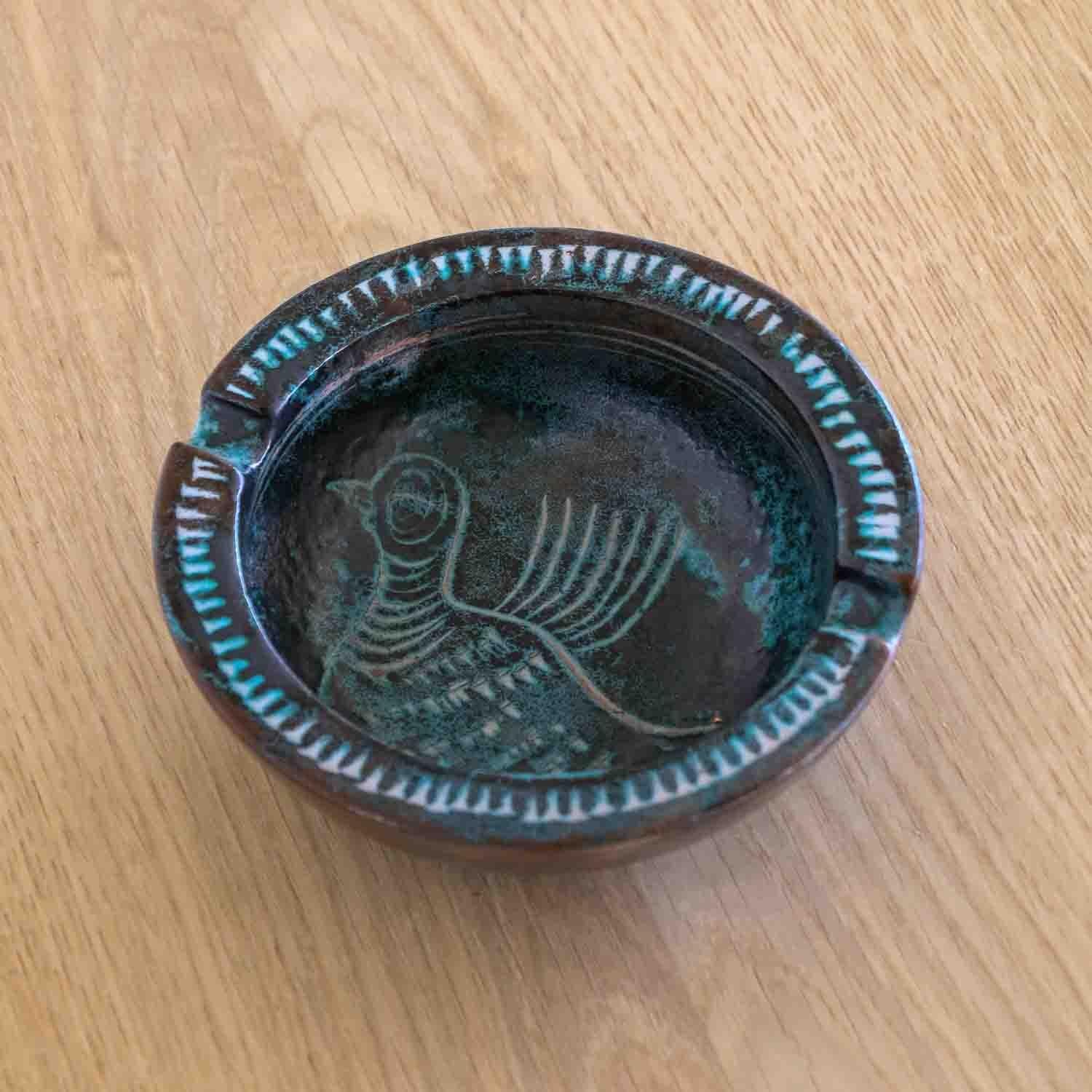 Wonderful painted ceramic ashtray from France, 1950's. Circular dish with small notches and green etched bird design on interior of bowl. Shades of dark brown and green glaze. Perfect as a catch-all or decorative piece. Signed underside.