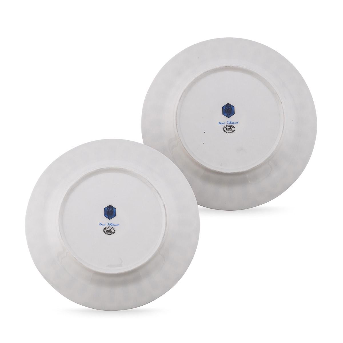 Hermès' Bleus d’Ailleurs pair of dessert plates, crafted in France from blue and white porcelain, showcases a geometric design inspired by ancient pottery. These classic hues symbolize centuries of travel between Europe and Asia.

The designs are