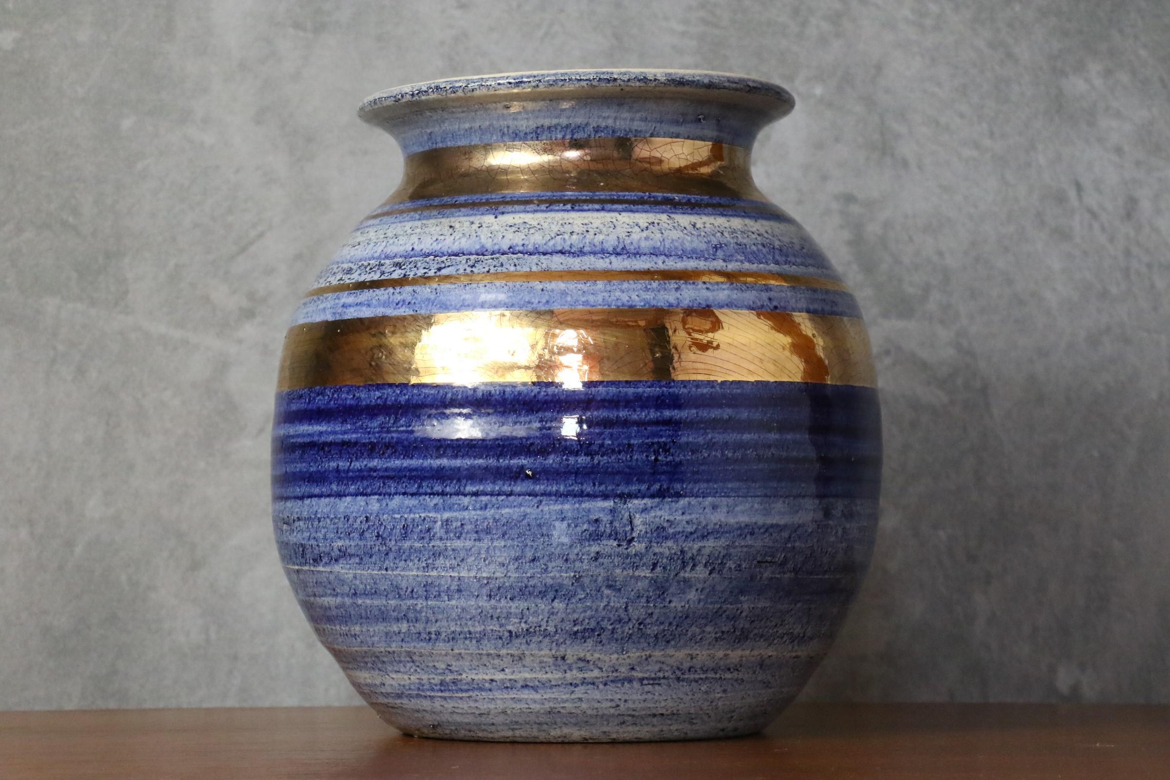 French Ceramic blue and golden vase by Georges Pelletier, Signed - 1970s

The ceramic proposed here has an attractive design in deep shades of gold and blue . Handmade, it is glazed with a glossy crackle finish. The piece is signed in gold on the