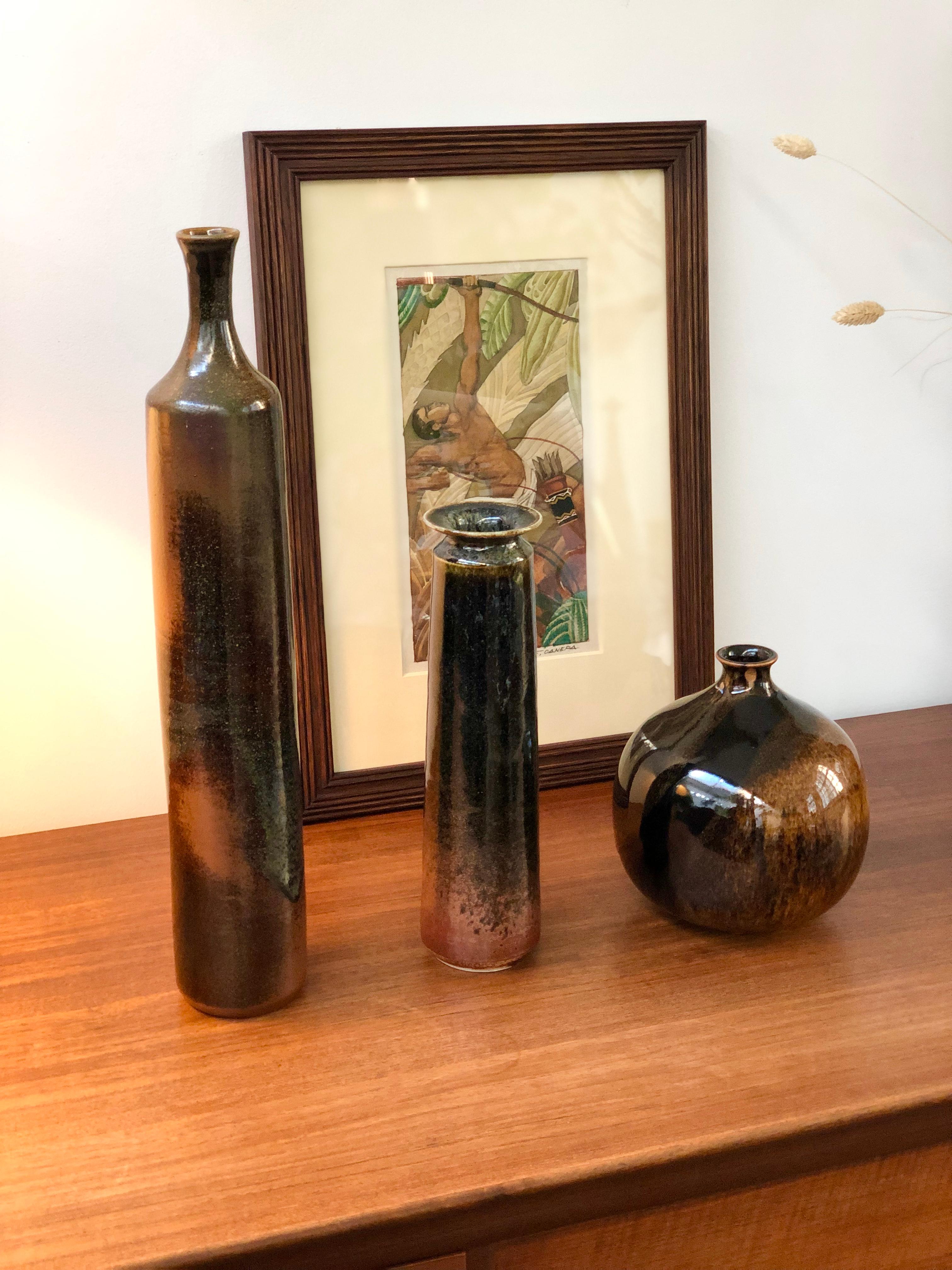 Large, tall ceramic bottle-shaped vase (circa 1960s) by unknown ceramicist. Wonderfully elegant with a luminous glaze, this tall, svelte, French vase will fill a room with its presence. The piece is two-toned, top and bottom present a dark brown