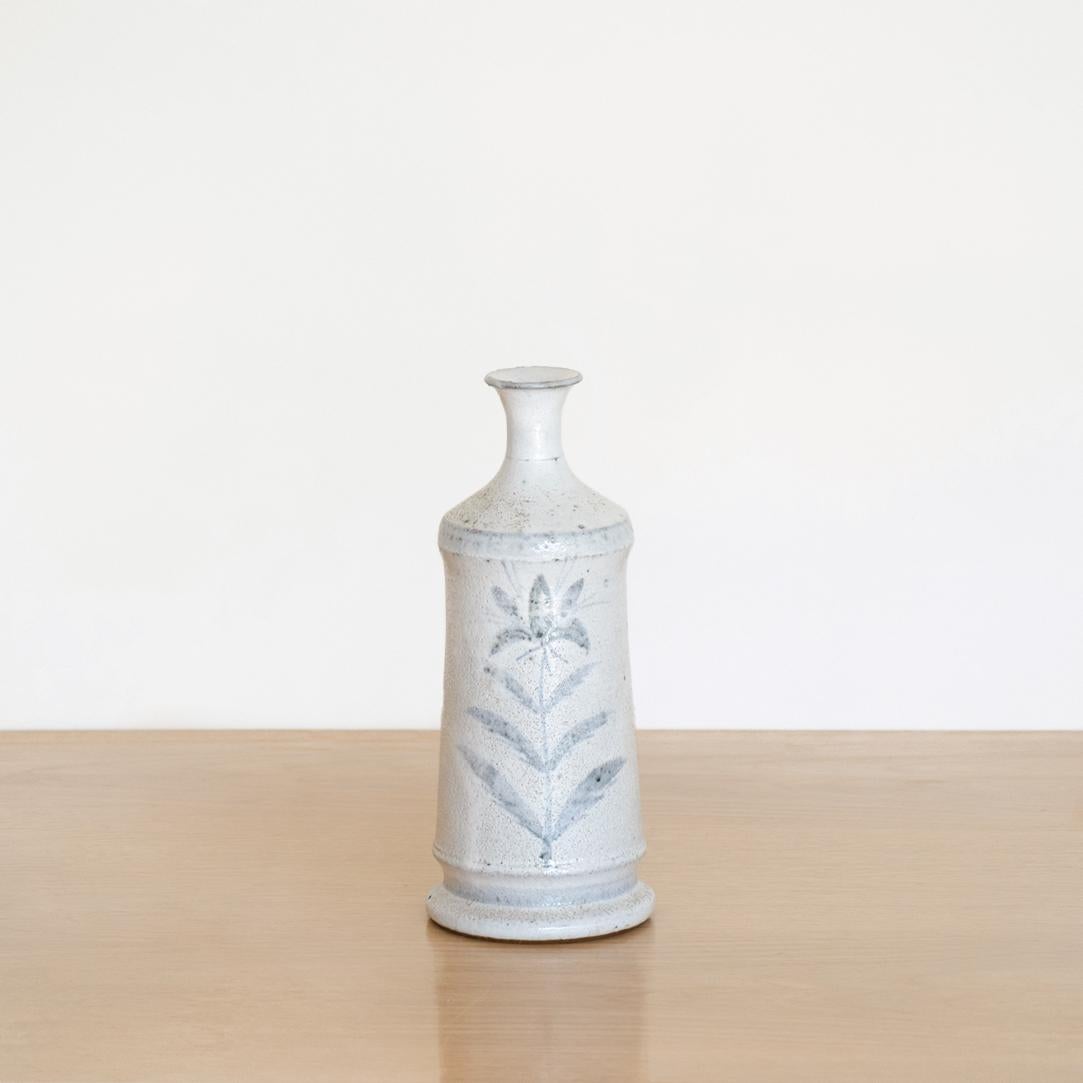 Beautiful ceramic bottle vase by French maker Vallauris from the 1960's. Blue painted flower motif on white glaze.