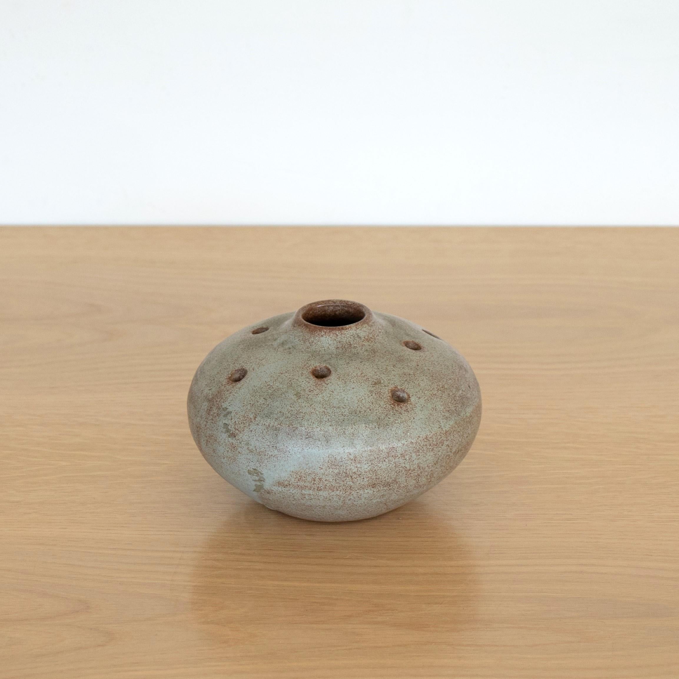 Great ceramic bud vase from France, 1950's. Petite round vessel with holes speckled in a natural grey glaze. Perfect as a bud vase or decorative object. 