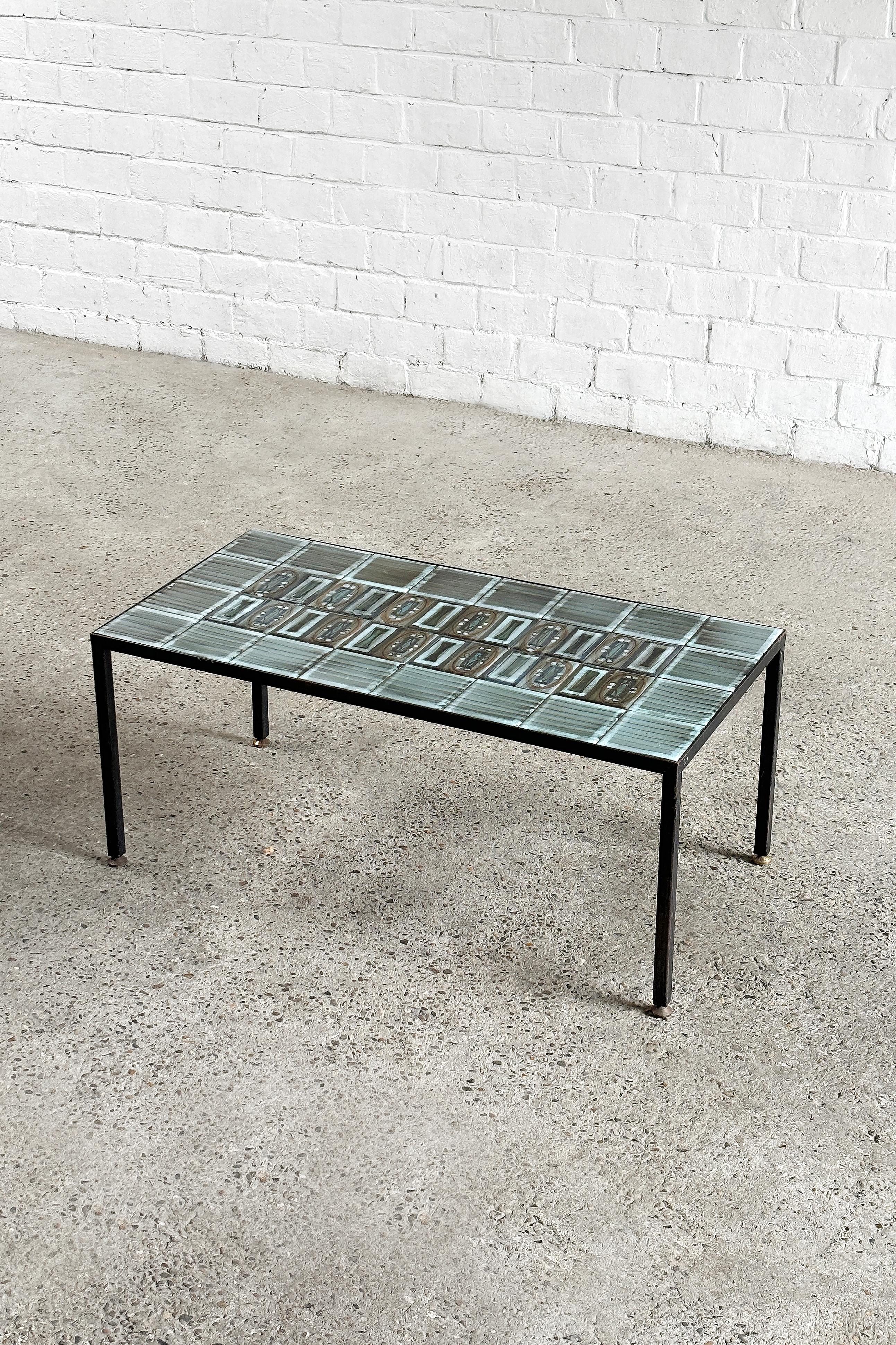 Coffee table in black lacquered metal with decorative ceramic tiles in gray, blue and green tones. French work from the 1960's. This table is attributed to ceramist Jean de Lespinasse, notable for the close resemblance in ceramic patterns and