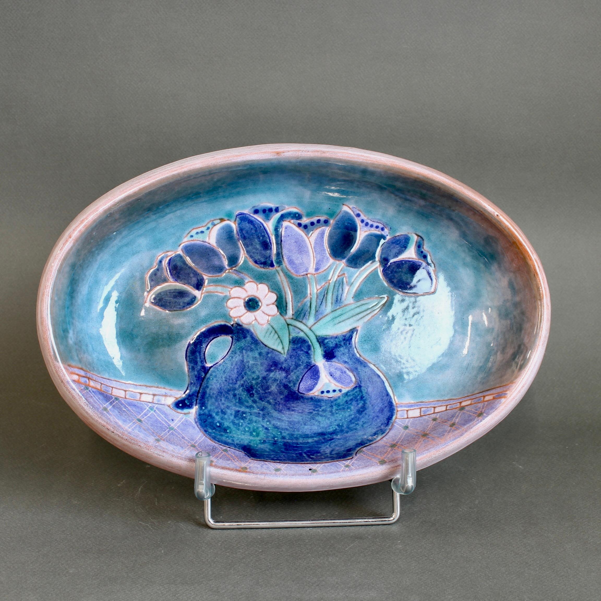 French ceramic decorative platter by the Frères Cloutier (circa 1970s). A charming decorative platter created in the trademark hues of the brothers Cloutier; as such, it is immediately identifiable as their work. Painted at the centre of the platter