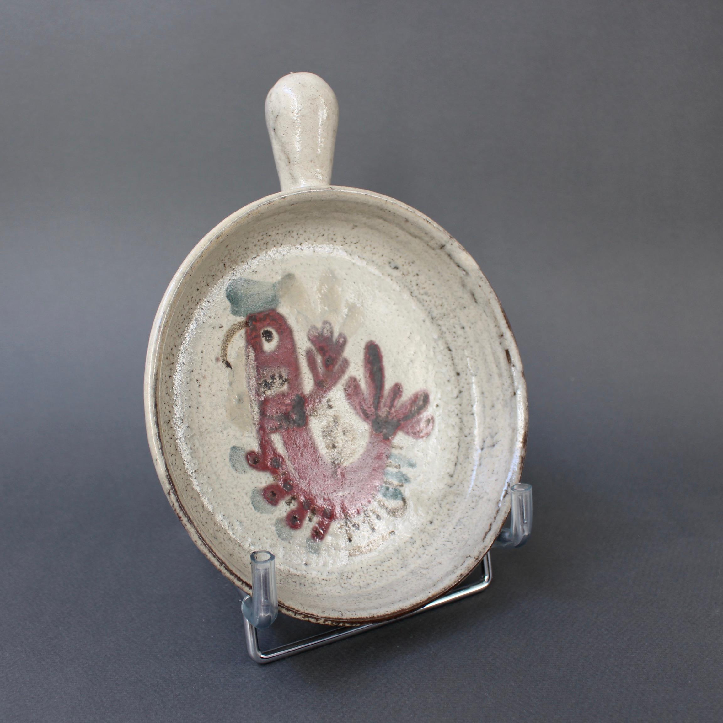 French ceramic small serving dish by Gustave Reynaud and Le Mûrier (circa 1960s). Shallow bowl-shaped ceramic piece and handle with French coq motif hand painted in the recess in Le Mûrier's trademark colours and decoration scheme. The rooster is