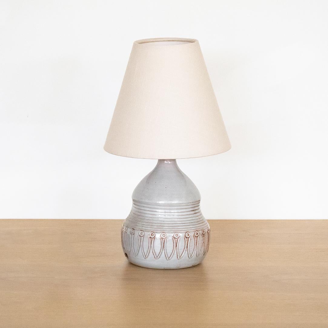 Vintage French ceramic lamp with etched detailing. Glazed ceramic in hues of muted grey and peach. Newly rewired and new linen shade.