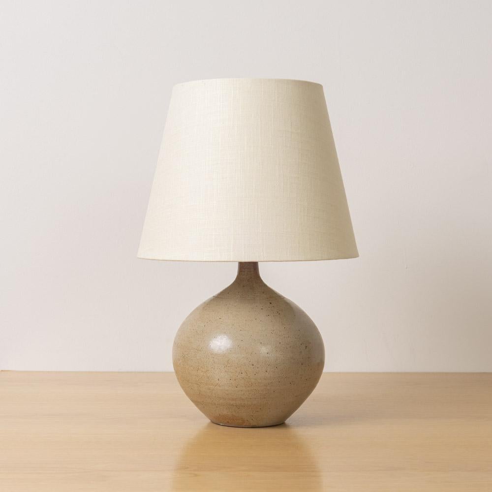 Lampada bulbosa in ceramica vintage proveniente dalla Francia, anni '60. Base in ceramica smaltata opaca dai toni neutri con macchie di colore marrone chiaro. Appena ricablato con un nuovo paralume in lino affusolato. Utilizza una lampadina con base