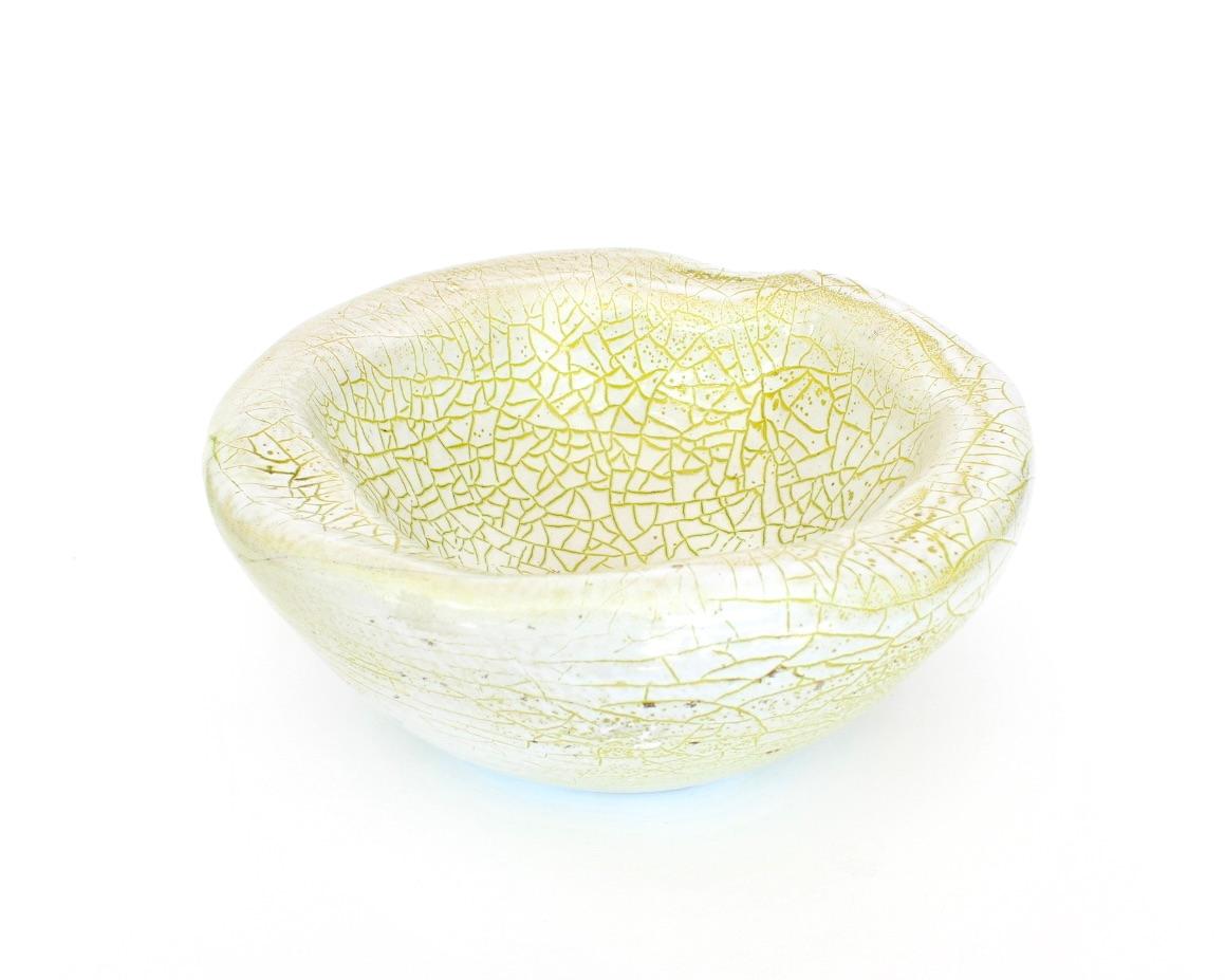 A large Accolay French ceramic dish with palest of chartreuse green heavily crackled glaze. 
This dish has an undulating organic rim edge. 
An atypical color for Accolay makes this dish very desirable. Signed and numbered. No chips or restorations.