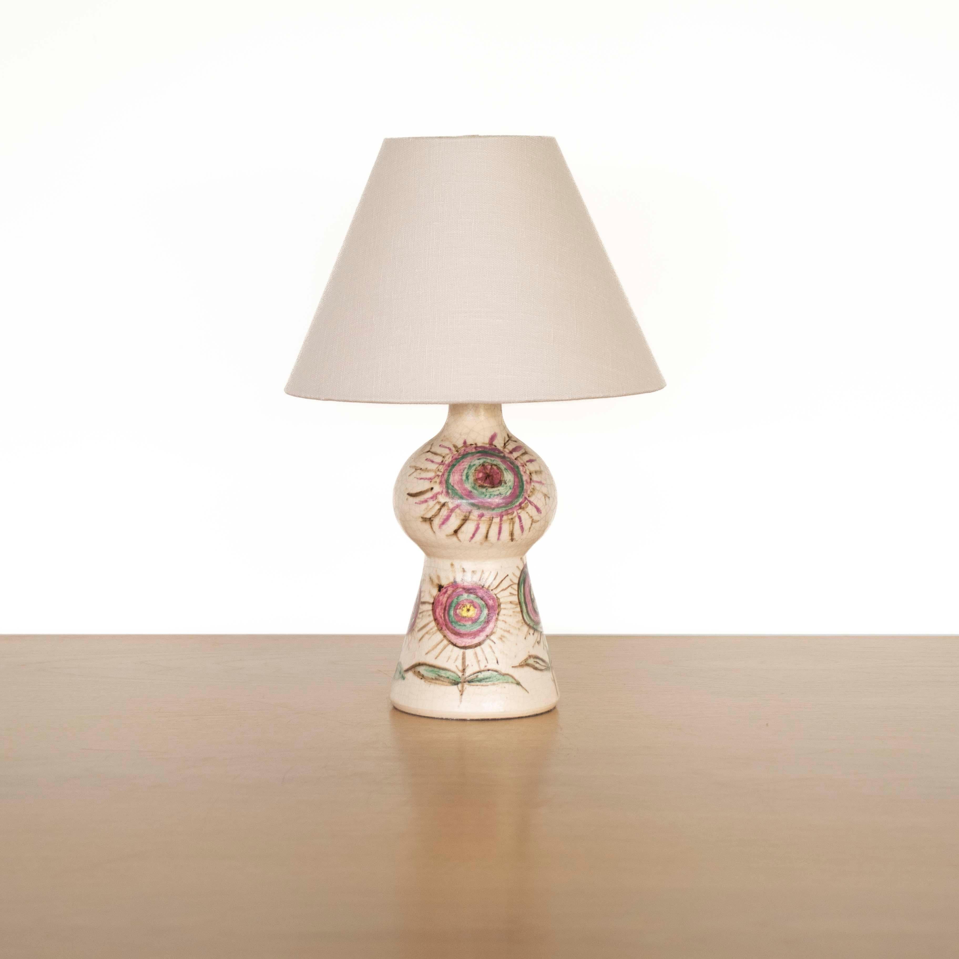 Beautiful French ceramic table lamp from France, 1960's. Off-white crackled glazed base hand-painted flowers in vibrant shades of pink, blue, green, and brown. New tapered linen shade and newly re-wired. Takes one E12 base bulb, 25W or higher using