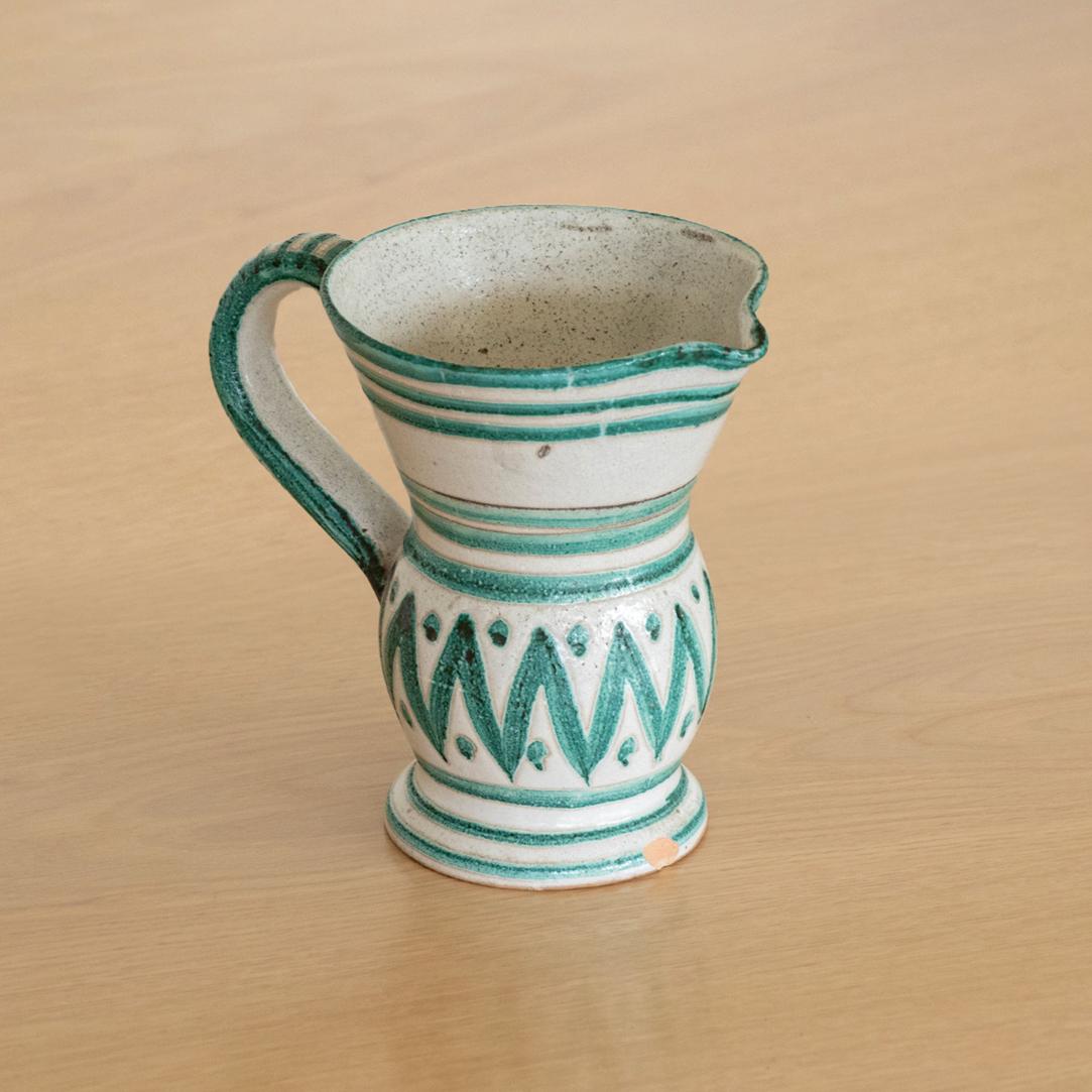 Beautiful painted ceramic pitcher from France by Robert Picault. Curved handle with painted green stripes and zig-zags on matte white glaze. Signed RP on bottom. Small chip near base.