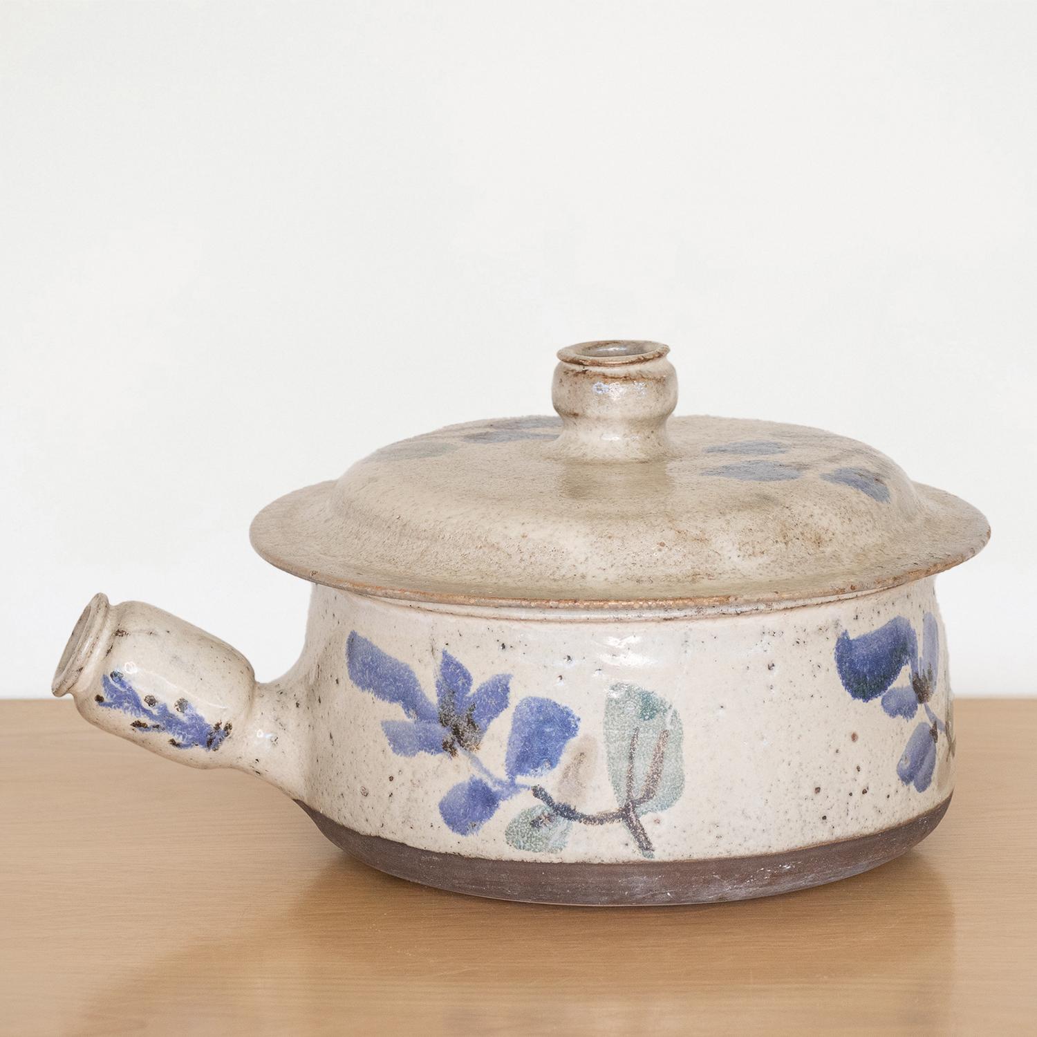 Beautiful hand painted pot with lid by Gustave Reynaud from France. White-grey glaze with blue and green painted floral motif. Handle and removable lid. Stunning display piece. Signed.
