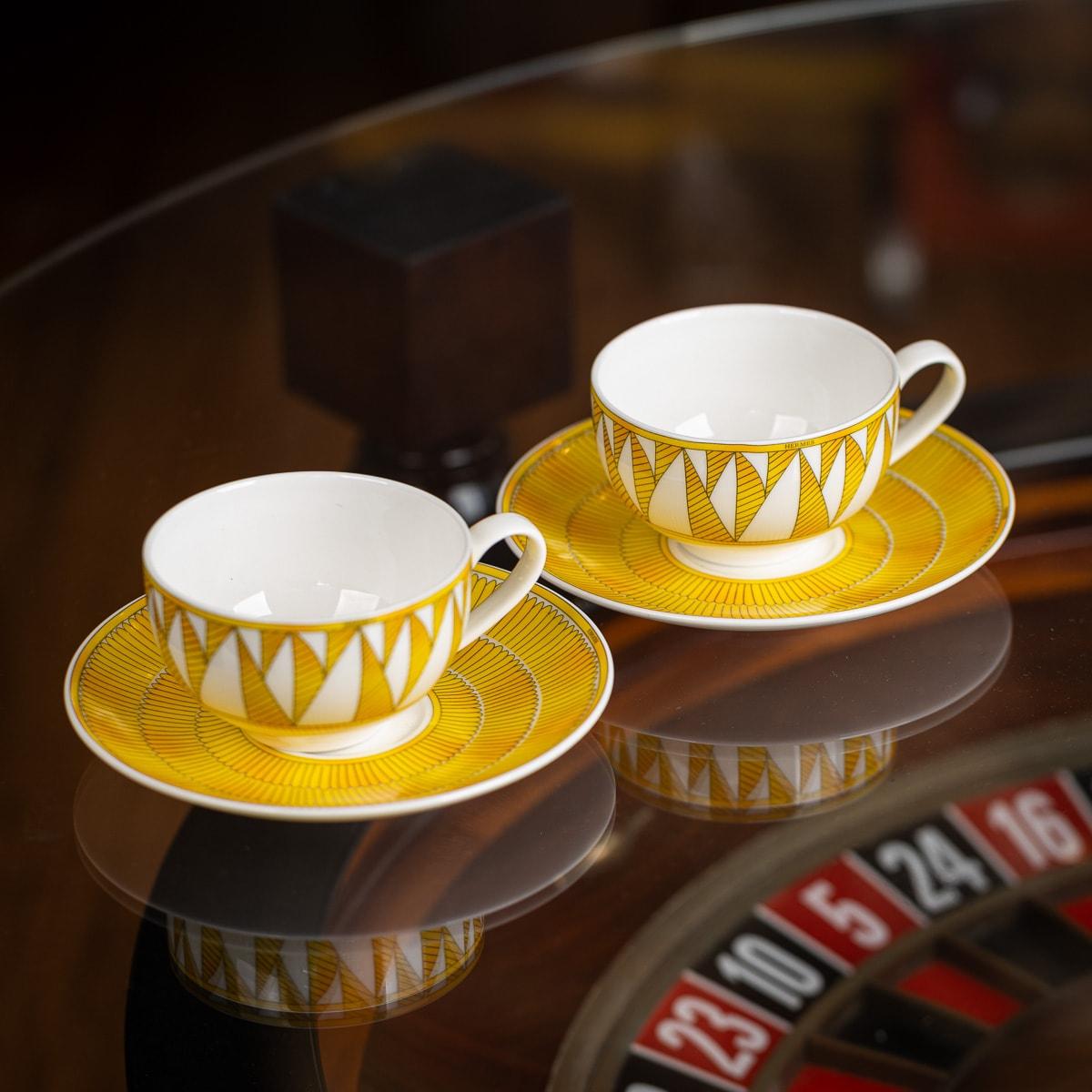 Hermès, Soleil d’Hermès pair of Breakfast Cup and Saucer in Porcelain. The decorations are screen-printed and applied by hand. It combines the white of the porcelain with a deep yellow, highlighted by the delicate lines that form a kaleidoscope of