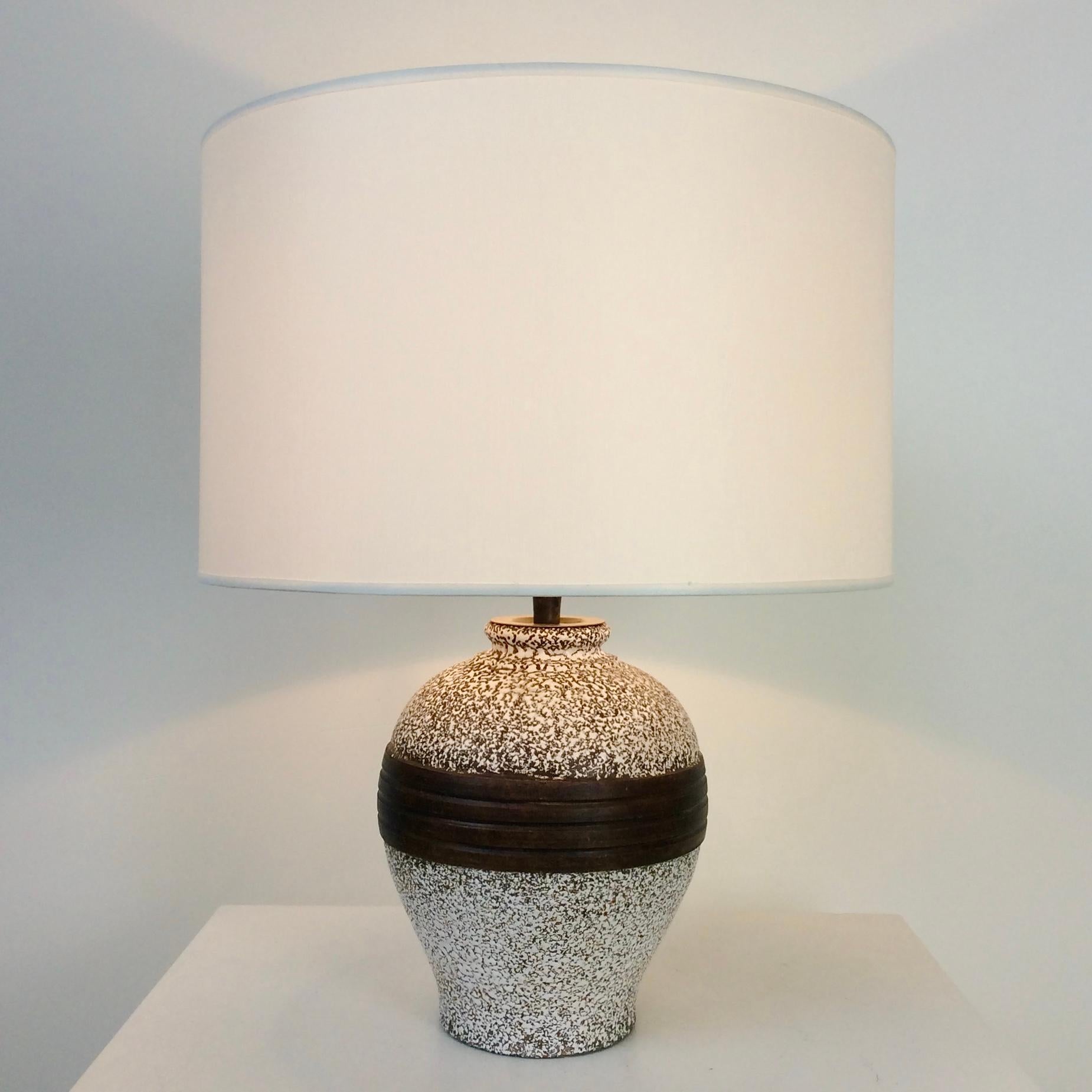 Lampe de table en céramique, vers 1940, France.
Céramique brune, décor émaillé blanc.
Nouvel abat-jour en tissu blanc.
Recâblé. Une ampoule E27 de 60W.
Dimensions : 45 cm de haut, 35 cm de large, 35 cm de profondeur : 45 cm H, 35 cm L, 35 cm P.