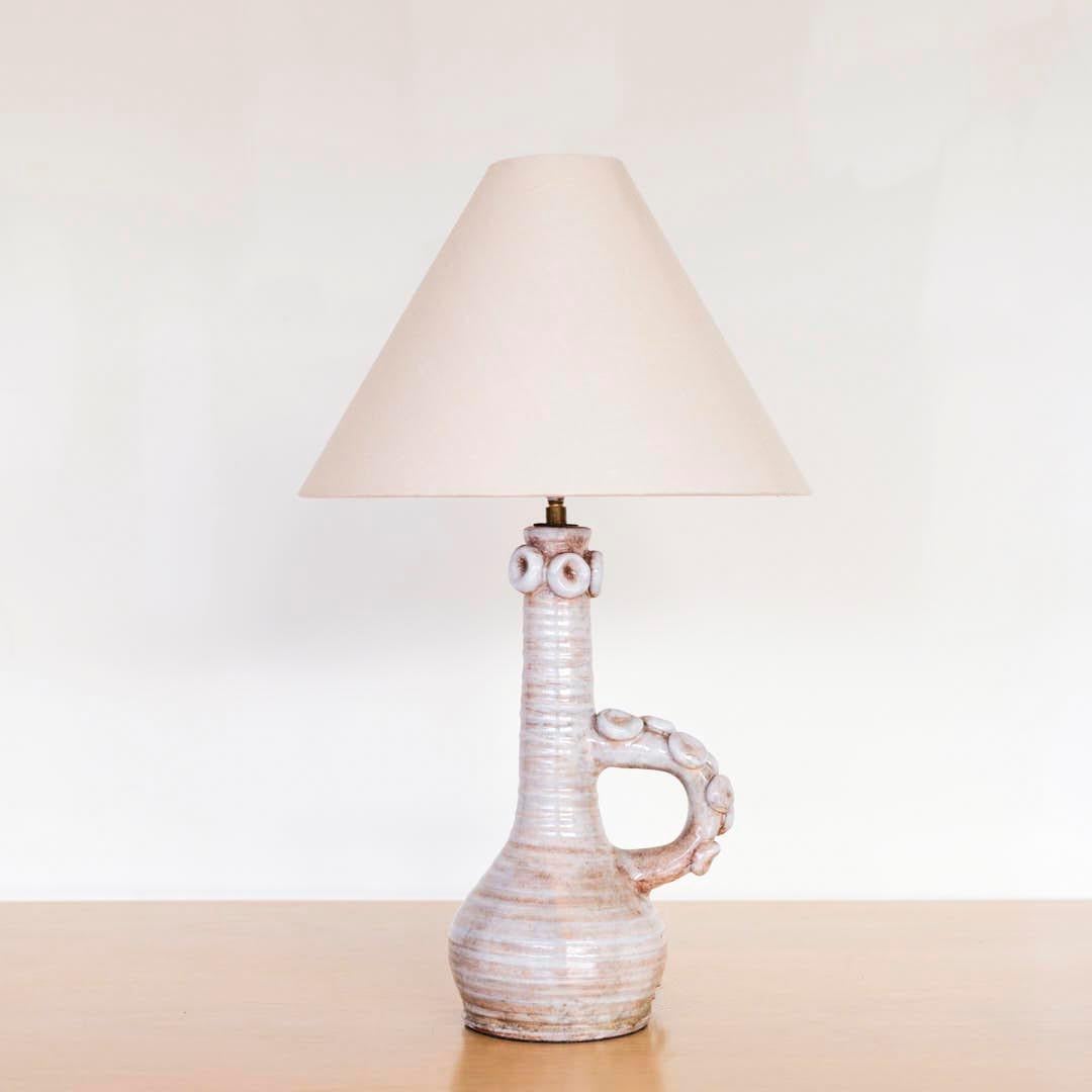 Lampe vintage en céramique de Vallauris, France, années 1960. Base et poignée en céramique émaillée de couleur gris clair. Jolis détails circulaires appliqués sur la poignée et le col. Nouvellement câblé avec un nouvel abat-jour en lin effilé.
