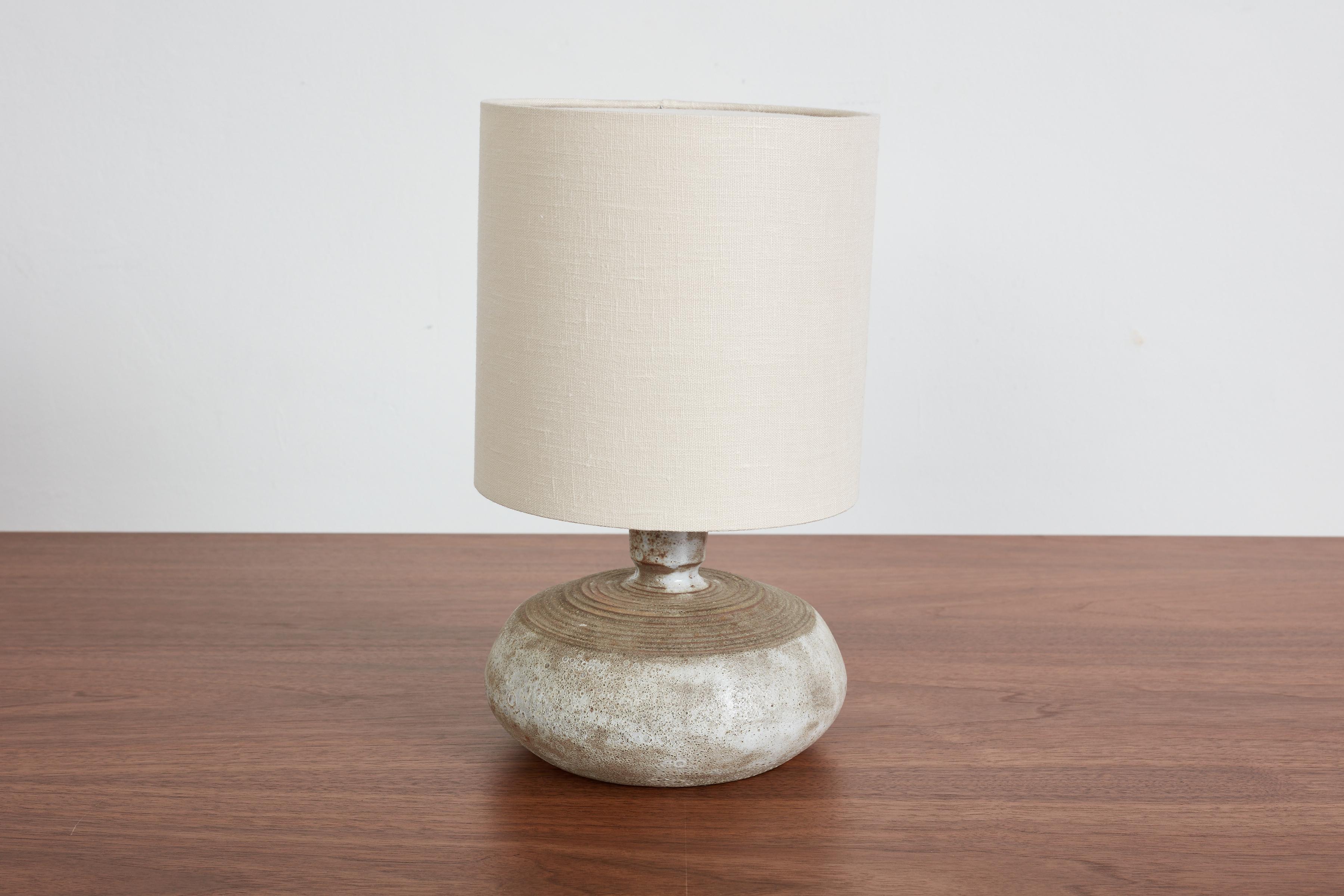Petite French Ceramic table lamp with wonderful organic shape and imperfect patina. 

France, 1950s

New linen shade - newly rewired. 

