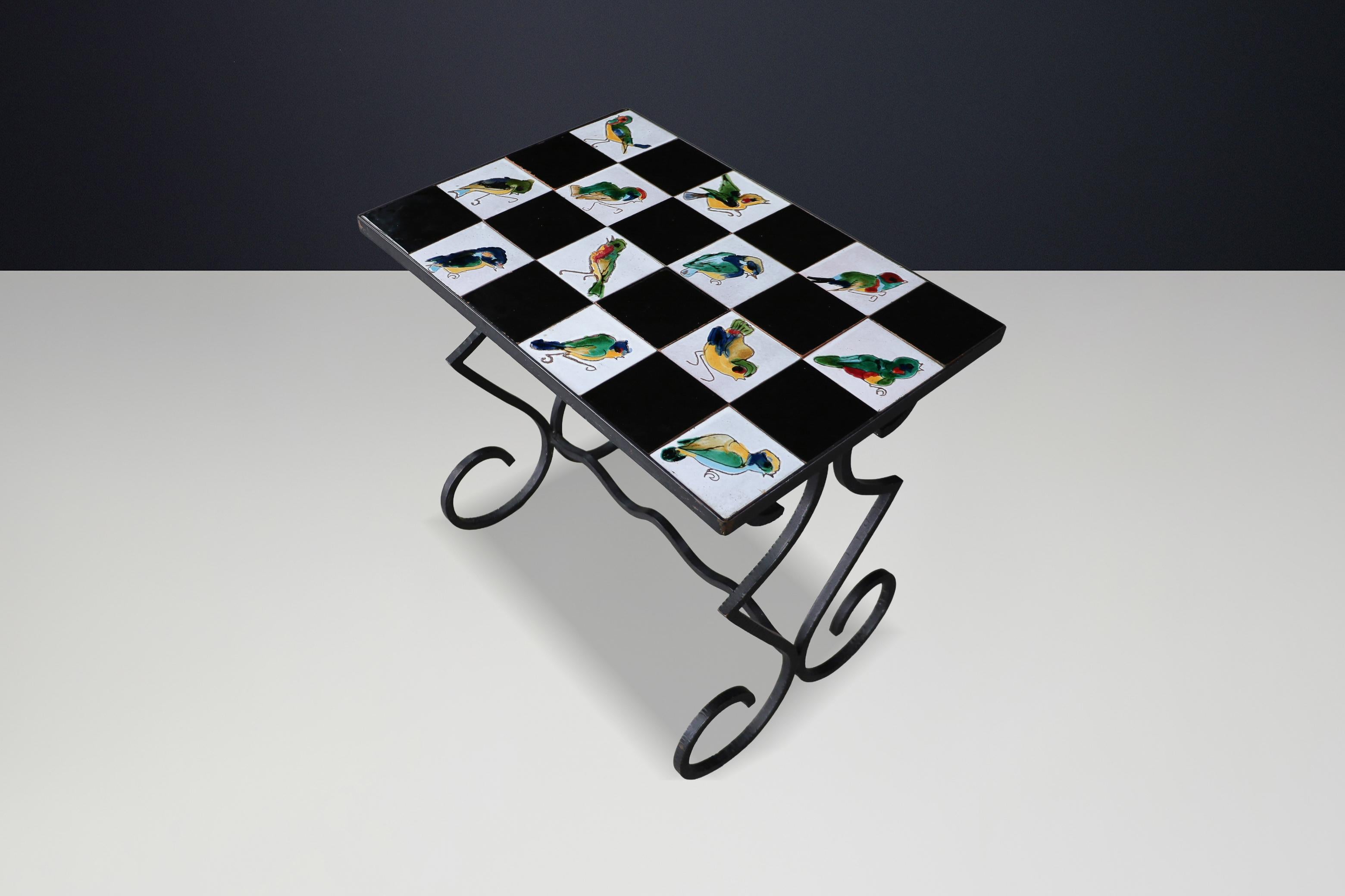 Charming French mid-century table with colorful hand-painted bird tiles and wrought iron base.

This French ceramic tile and wrought iron table from the 1950s is a delightful example of mid-century decorative design, blending artistry with function.