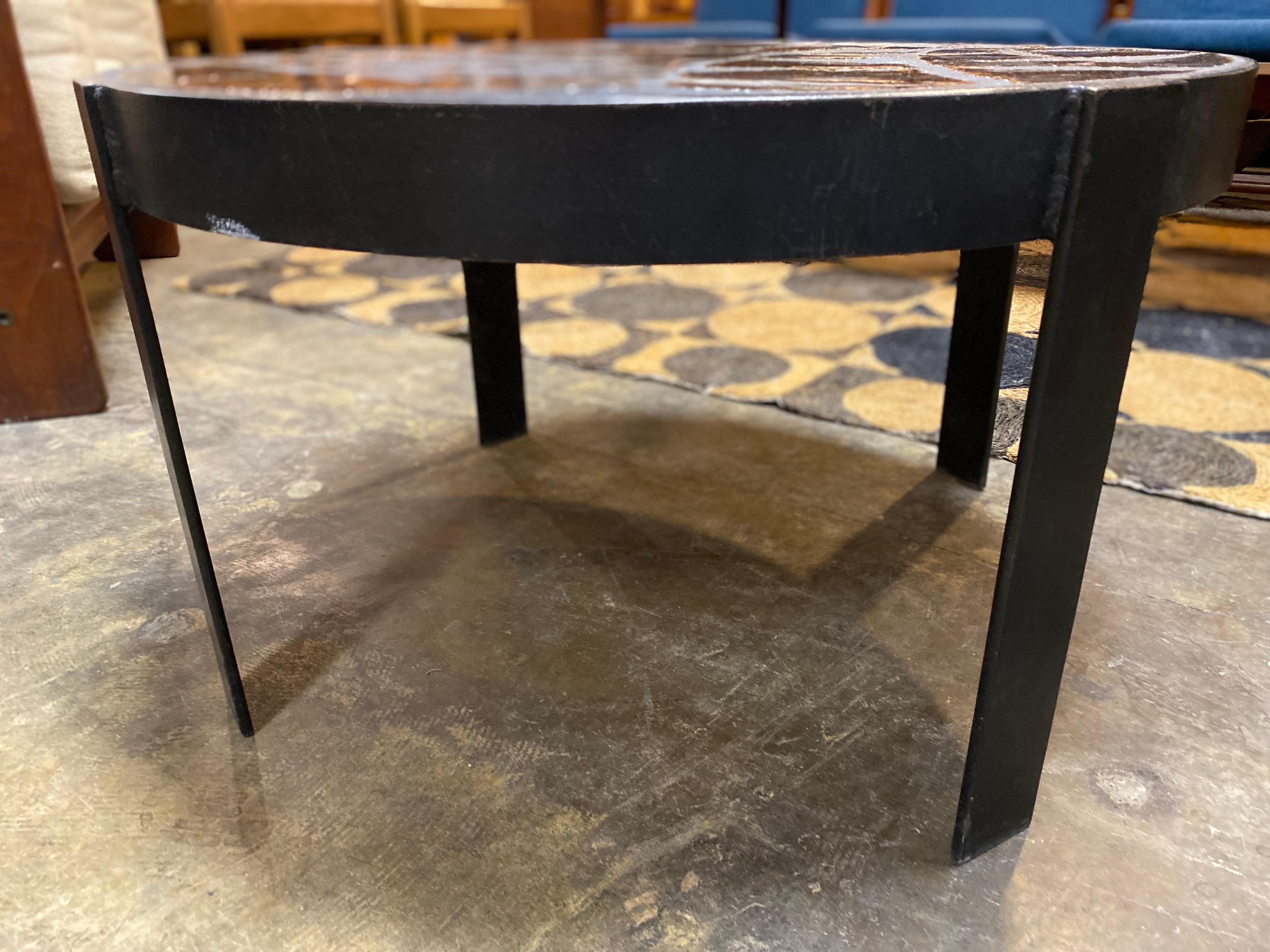 French ceramic tile cocktail table in the manner of Roger Capron. Glazed ceramic tiles sit on heavy iron base and is in good overall condition. 27