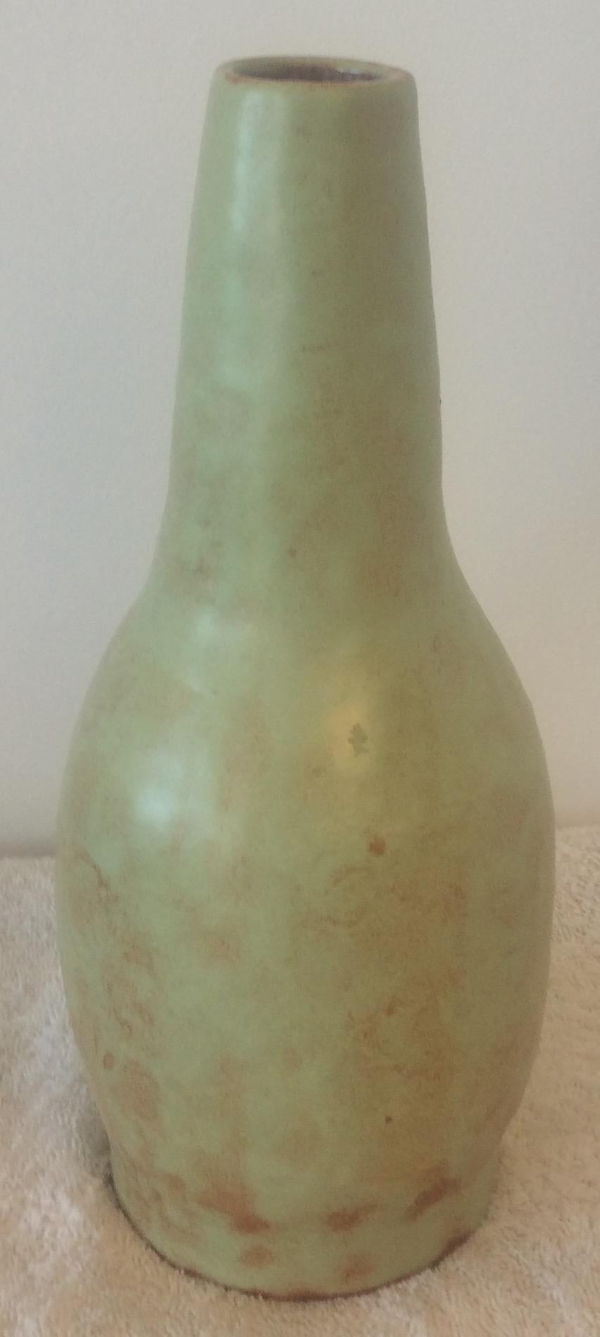 This dazzling glazed ceramic vase was handcrafted in Vallauris, France.
The primary pale green with terracotta colors are truly eye-catching. 

It can enhance any shelf, table, credenza or countertop as it is truly an interesting decorative