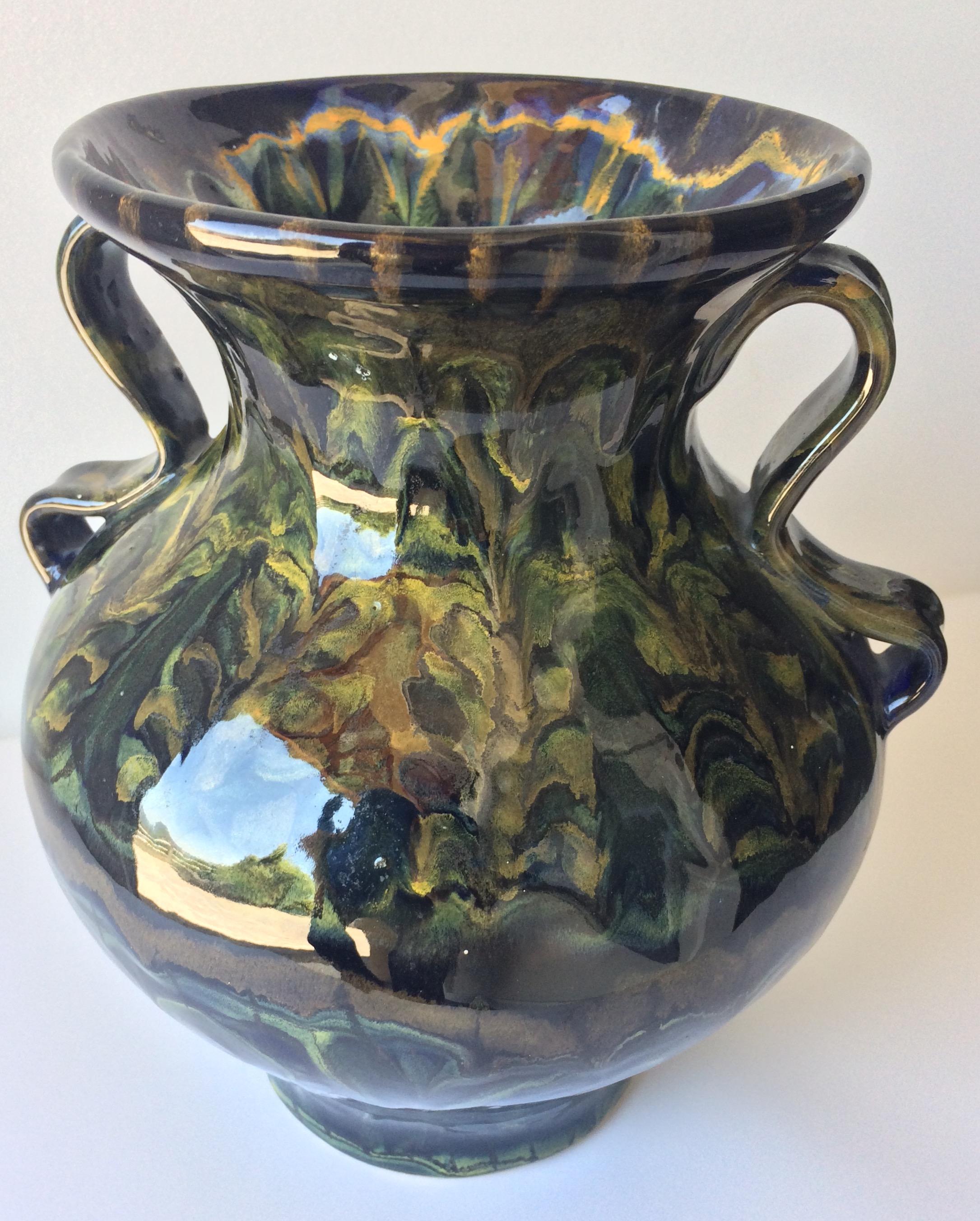 Dazzling glazed ceramic or stoneware vase. The underlying black, blue, orange, yellow and green colors and the swirling designs are truly eye catching. Made in Quimper, France by Keraluc Pottery Studio.

It can enhance any shelf, table, credenza or