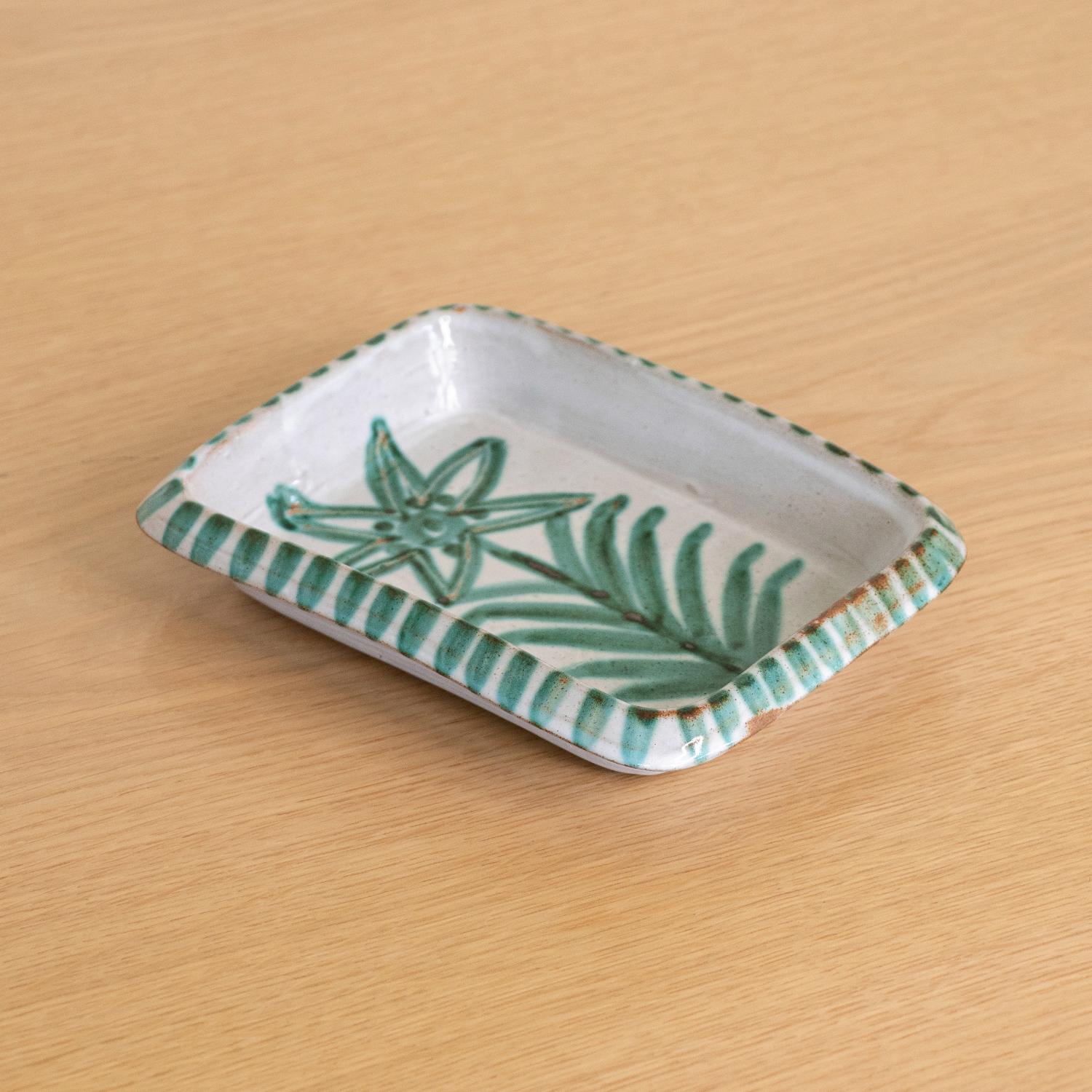 Beautiful painted ceramic dish by Robert Picault, France, 1950s. Rectangular dish with painted flower and green striped edge. Perfect as a catch-all or jewelry tray. Signed.