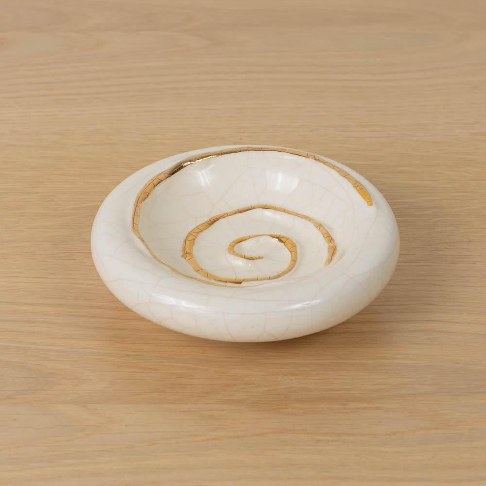 Precioso vide poche de cerámica francesa con esmalte crema brillante y detalle de espiral pintado en oro. Perfecta como pieza decorativa o cajón de sastre. Estampado en la parte inferior. 