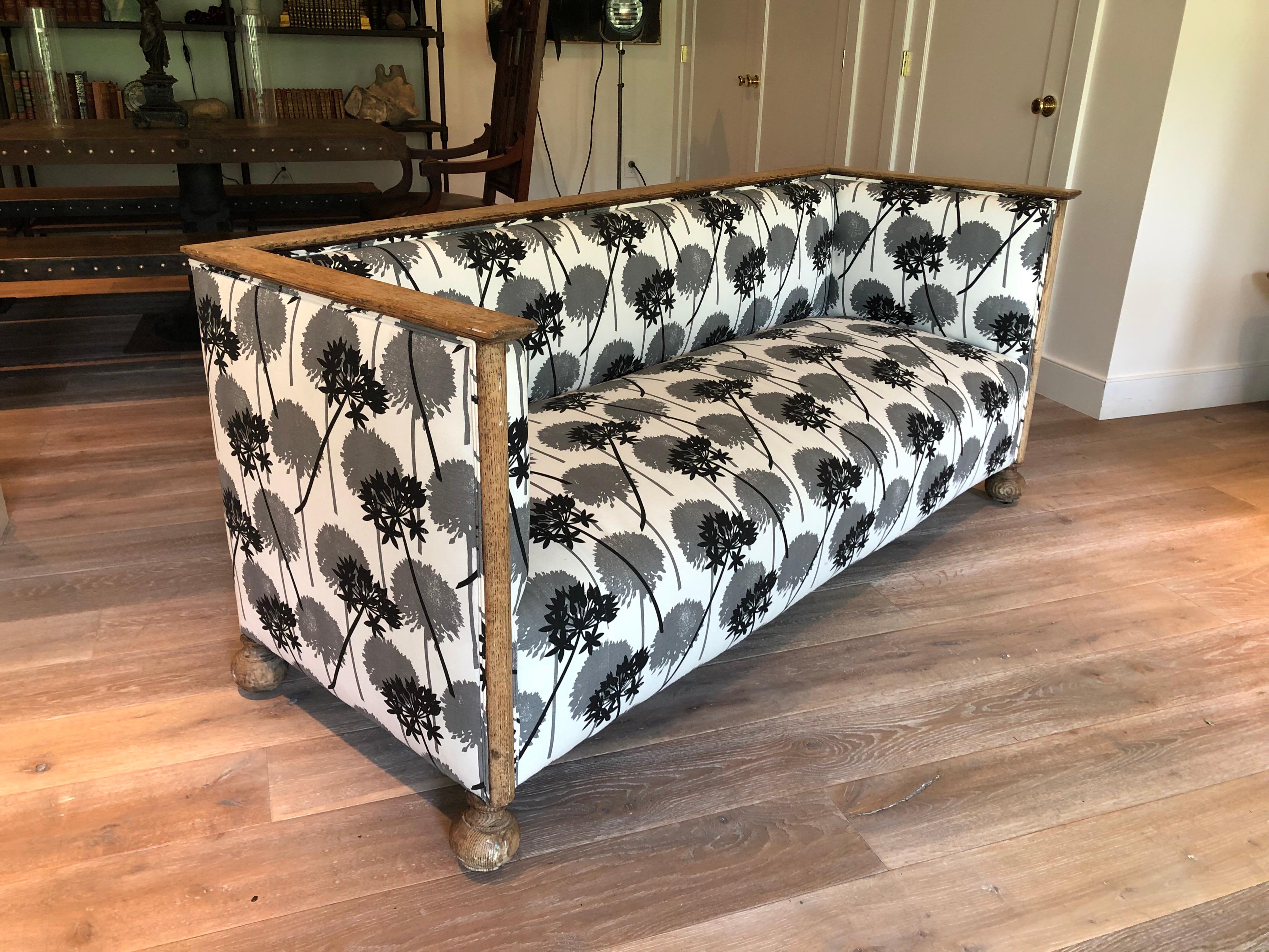 A French perused oak square frame sofa with bun feet. Upholstered in a contemporary allium print cotton canvas.