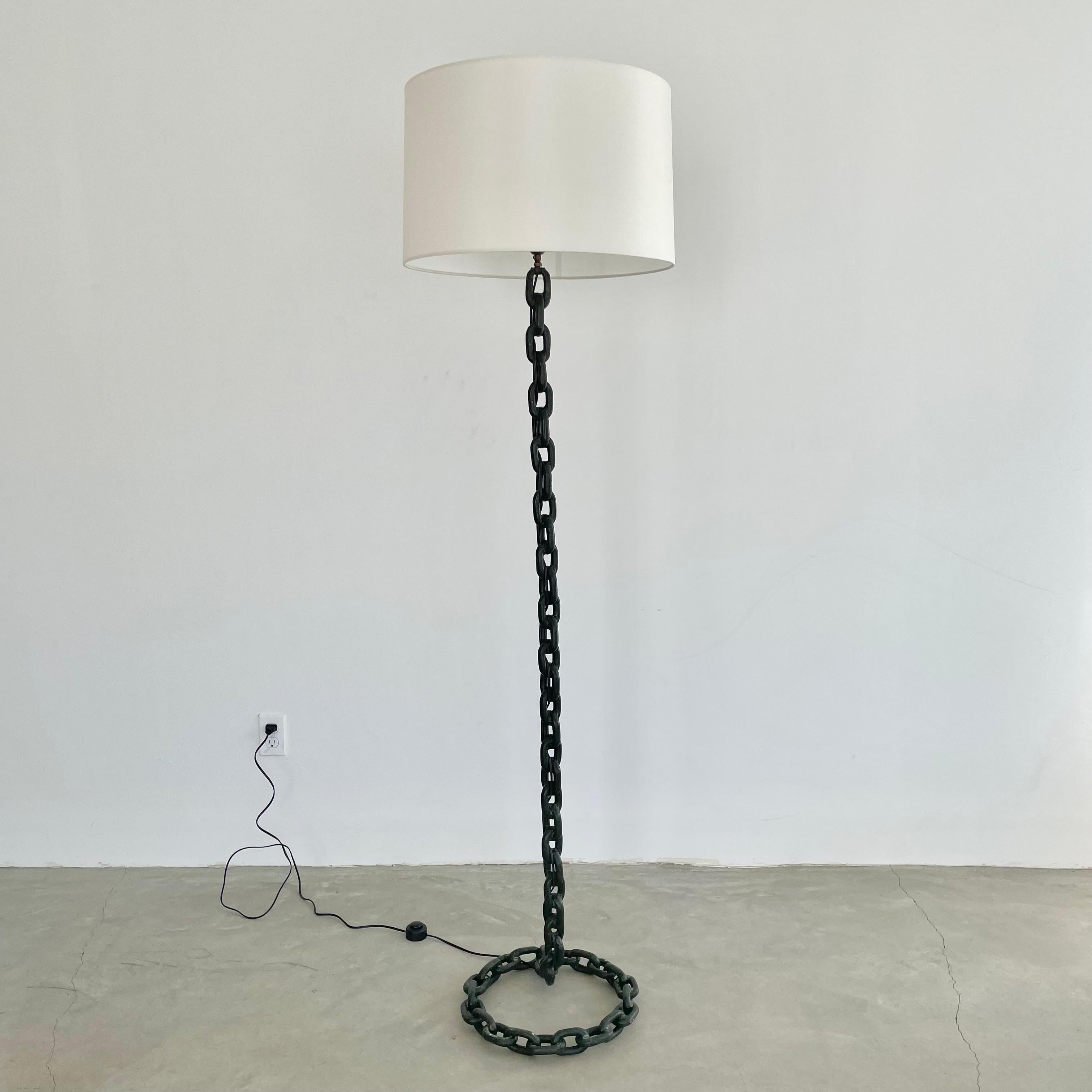 Brutalist iron chain link floor lamp, made in 1950s France. 6 feet tall. Extremely heavy and substantial lamp. Circular base with rustic iron boat chain welded together and painted in a dark green with years of patina. Features a new custom silk