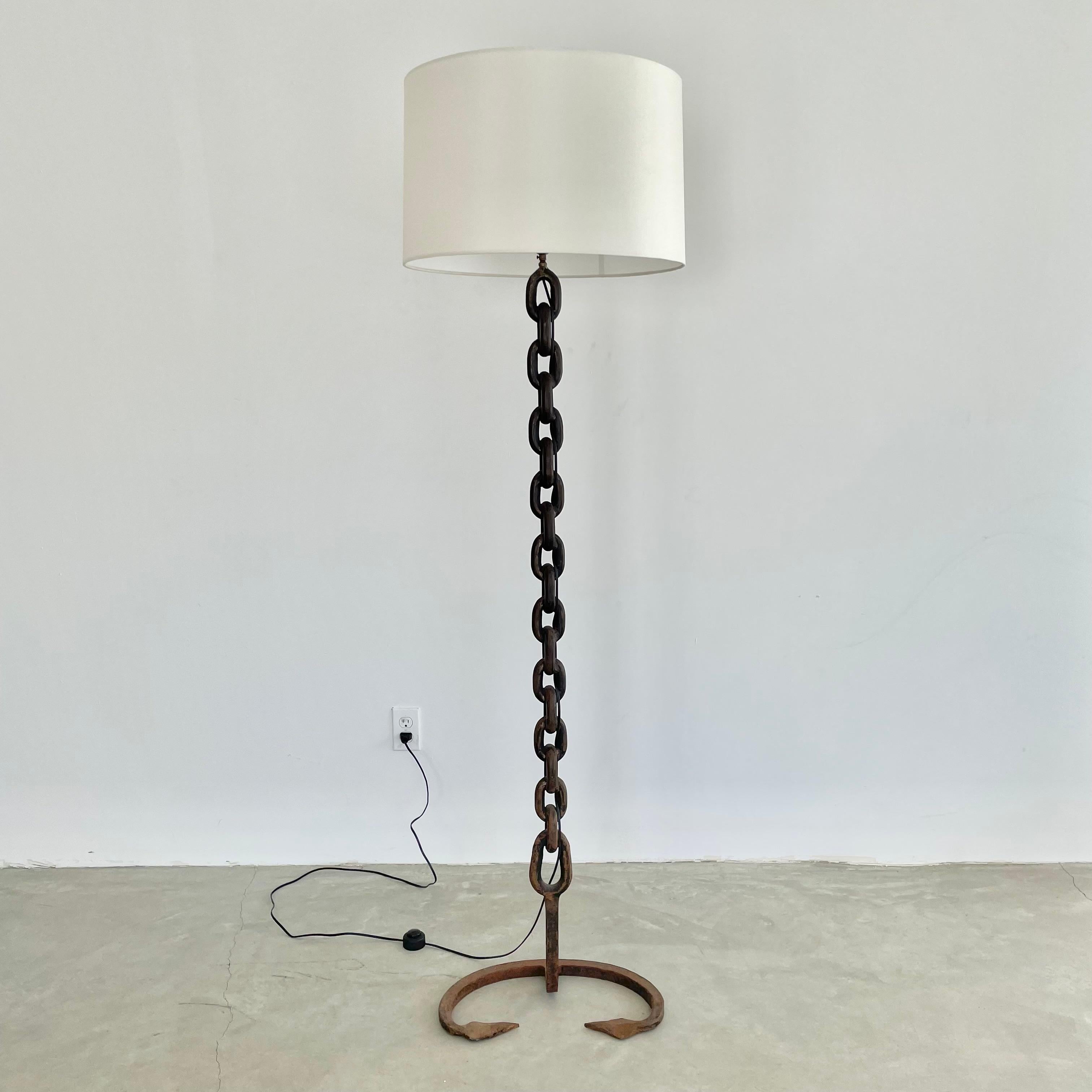 Brutalist iron chain link floor lamp, made in 1960s France. Just under 6 feet tall. Extremely heavy and substantial lamp with a thick chain link. Unique trident style base with rustic iron boat chain welded together and painted in a matte black with