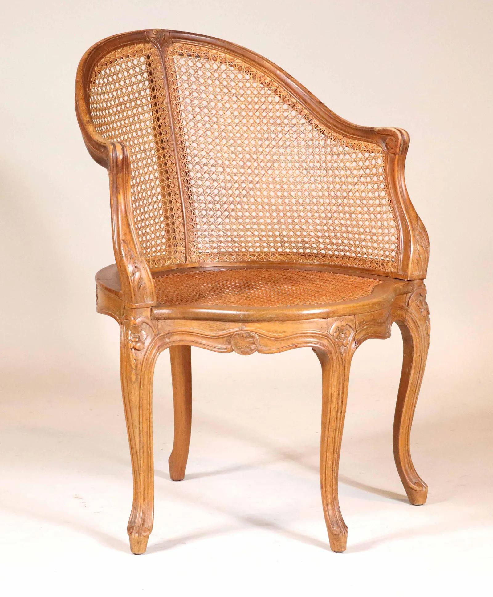 A Louis XV style fauteuil de bureau (desk chair) in carved beechwood with caned seat and back. Cabriole legs, scalloped apron, nicely carved decoration on back rail.