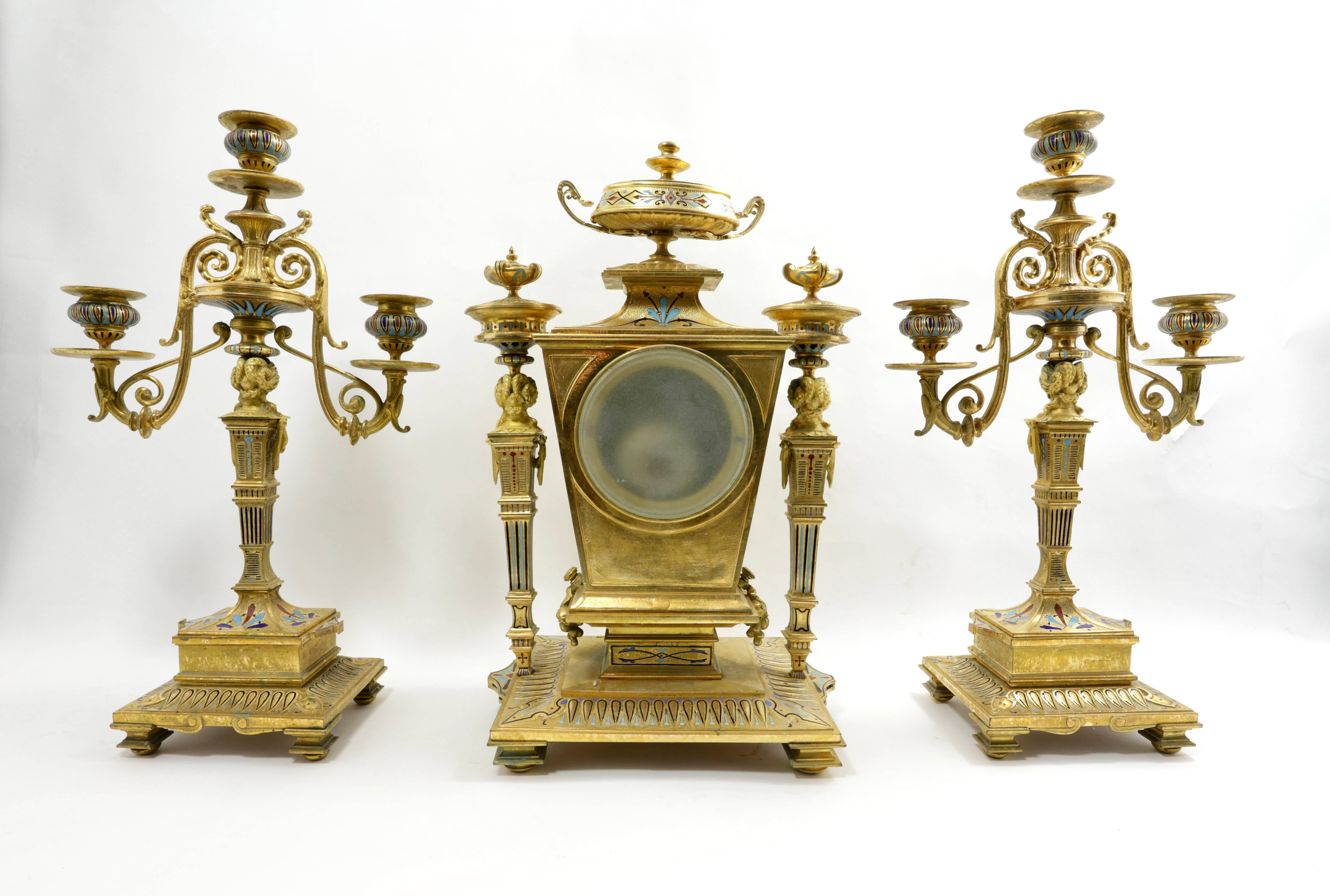 Fine quality French 19th century gilt bronze champlevé enamel three-piece clock set consisting of a clock and a pair of two-arm candelabras.