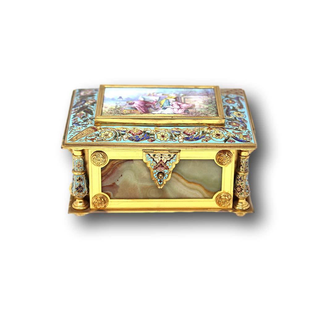 Coffret à bijoux en champlevé et onyx français du XIXe siècle. Le cercueil est de forme rectangulaire avec quatre piliers d'angle, un couvercle à charnière et un panneau peint. Le cercueil est largement décoré d'émaux multicolores et d'un travail du