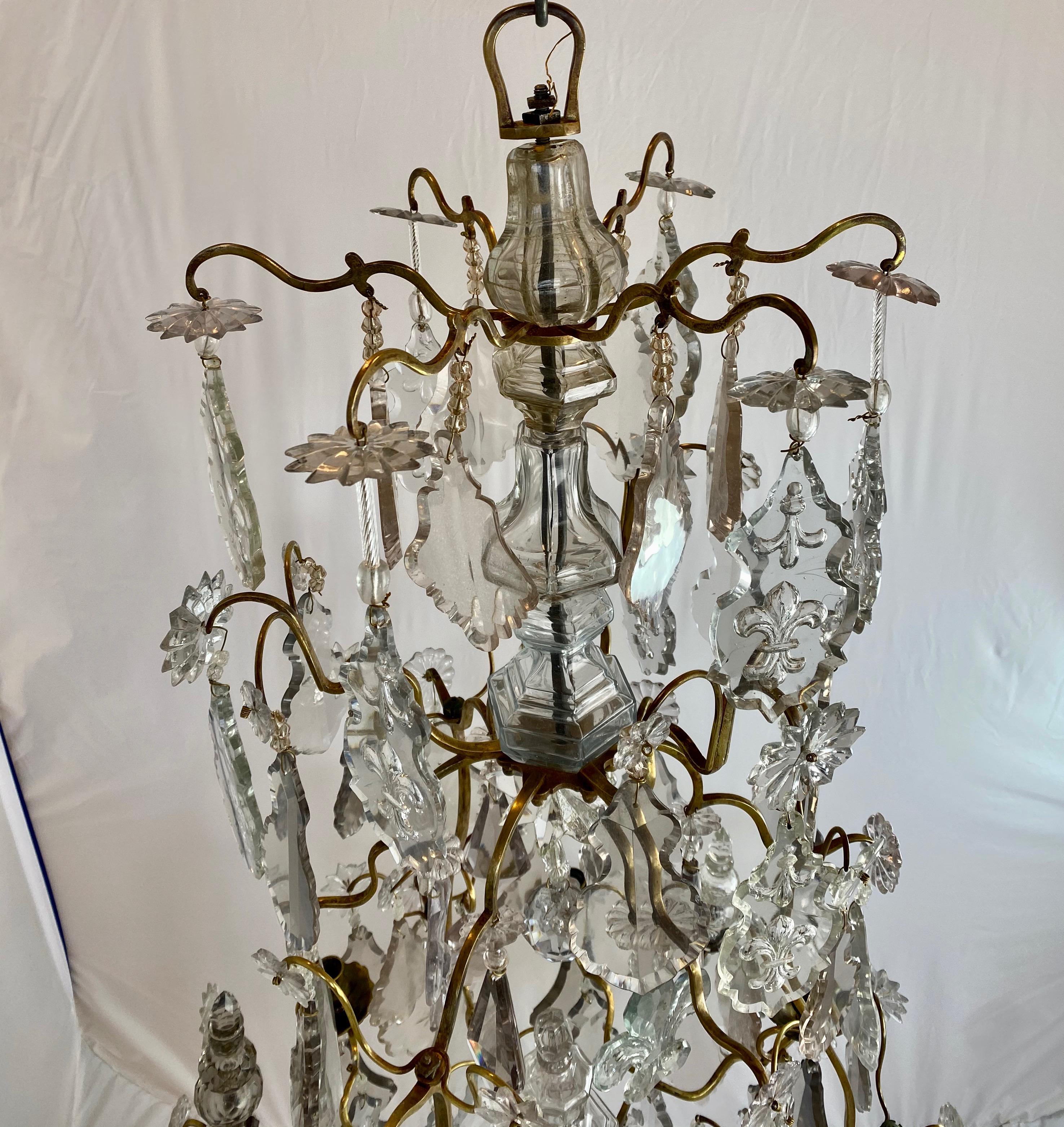A quite large French Baroque chandelier from the 18th c. The chandelier has a cage frame of brass/bronze with a number of leaf-shaped pendants hanging. Centrally in the chandelier is a standing obelisk that is blown. At the bottom the chandeliers