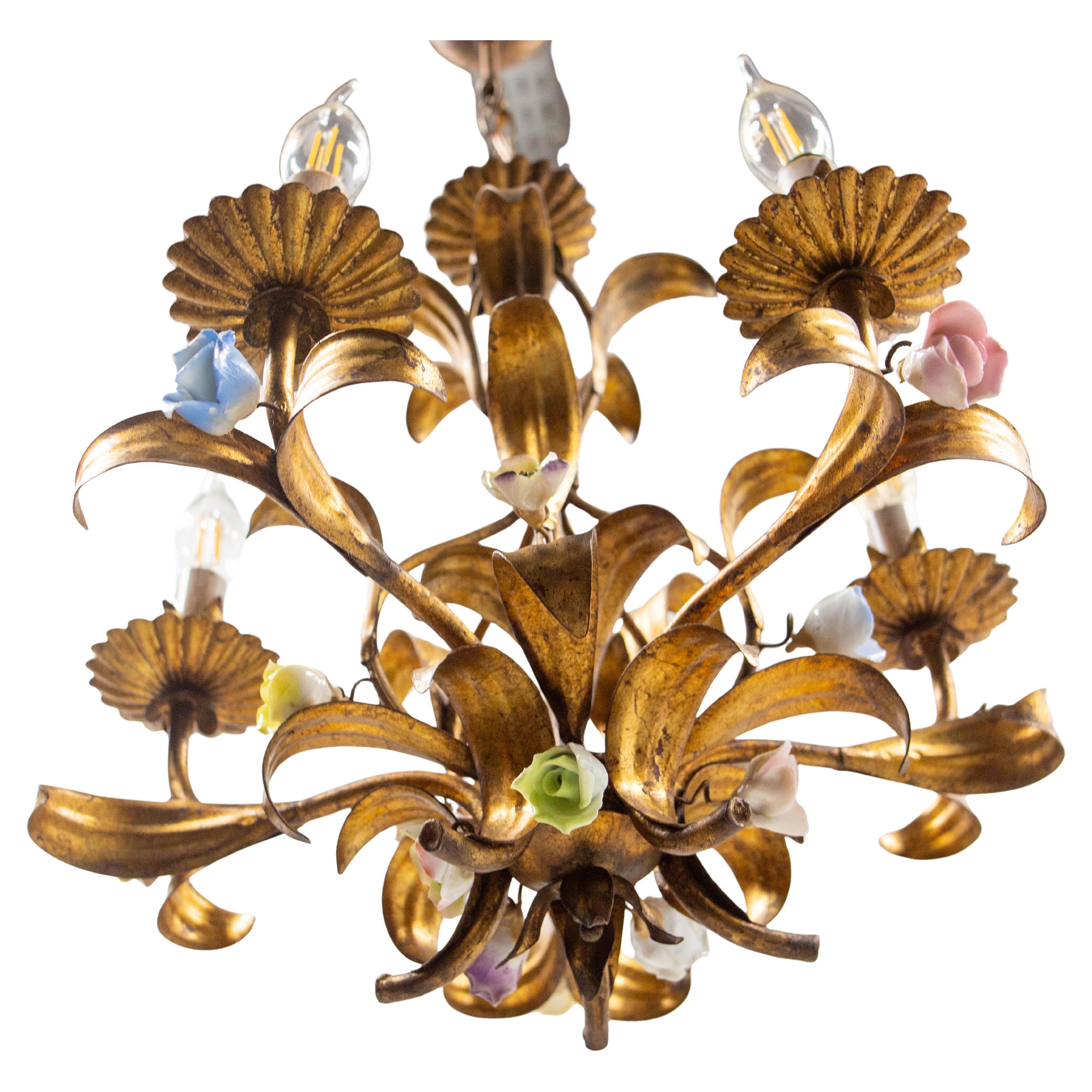 Lustre fabriqué dans les années 1950 
Feuilles de palmier en métal doré et fleurs en porcelaine (roses et coquelicots).
Bon état,

Hauteur sans la chaîne : 17.32 in. (44 cm)
Il est conforme aux normes des États-Unis, de l'Union européenne et du