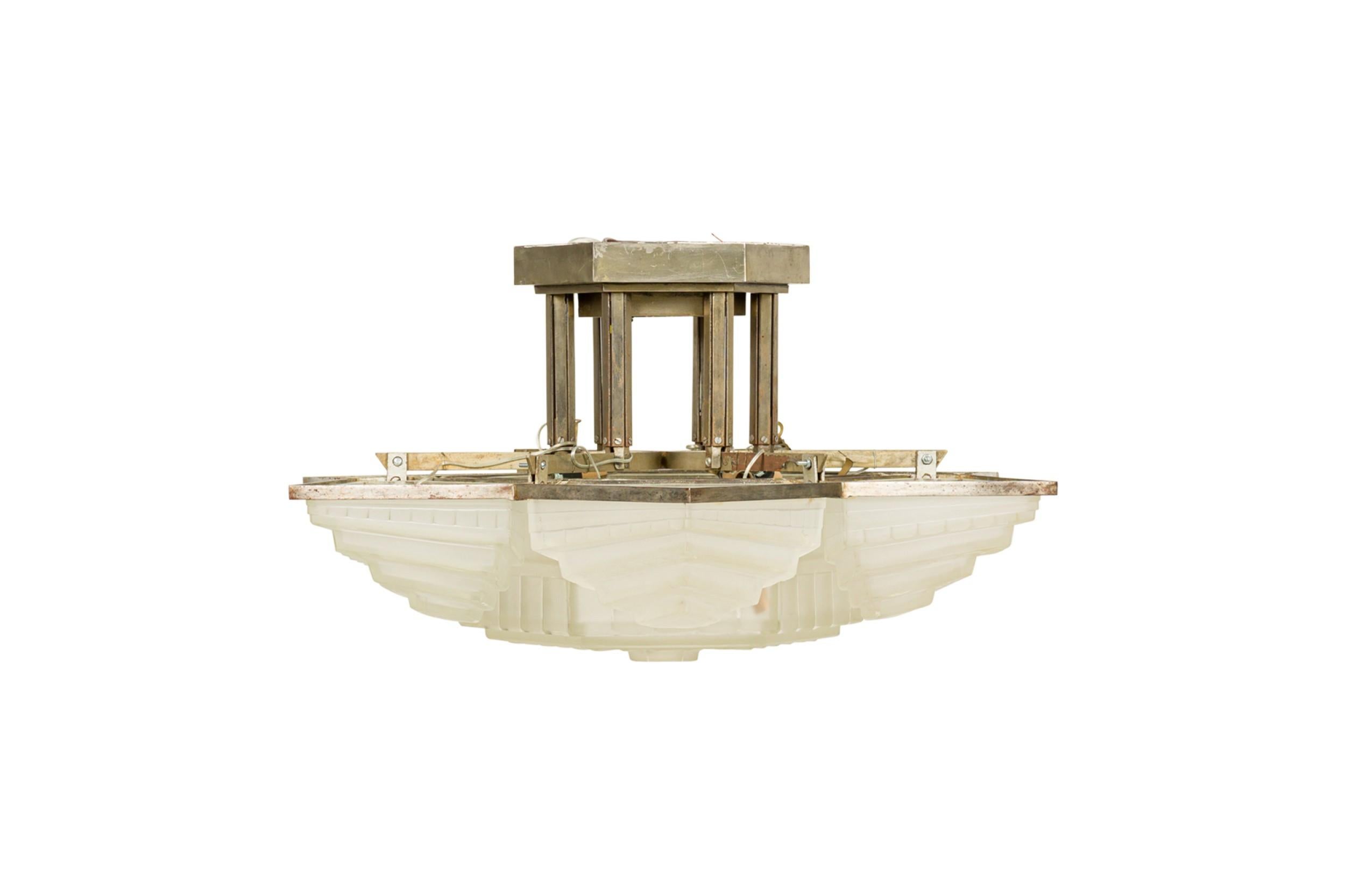 French Art Deco chandelier with 6 frosted triangular shaped 3-tier glass shades surrounding a large centered 6-sided geometric frosted shade supported in a metal frame