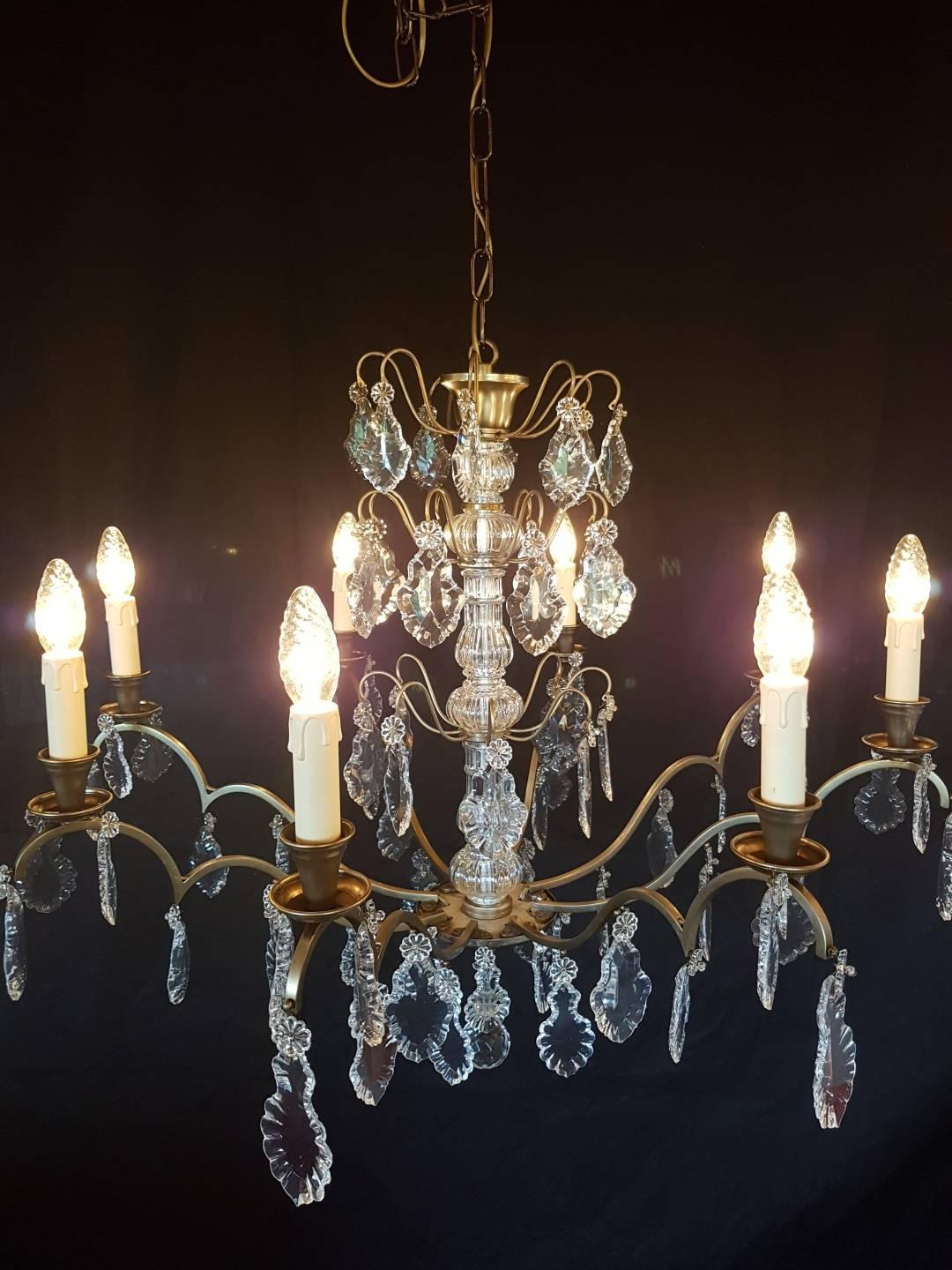 French chandelier with eight lights. Color between bronze and silver. Characteristic French glass in the centre. Nice because of it's simplicity.

This is just one of our large collection chandeliers. Besides the old and antique chandeliers we