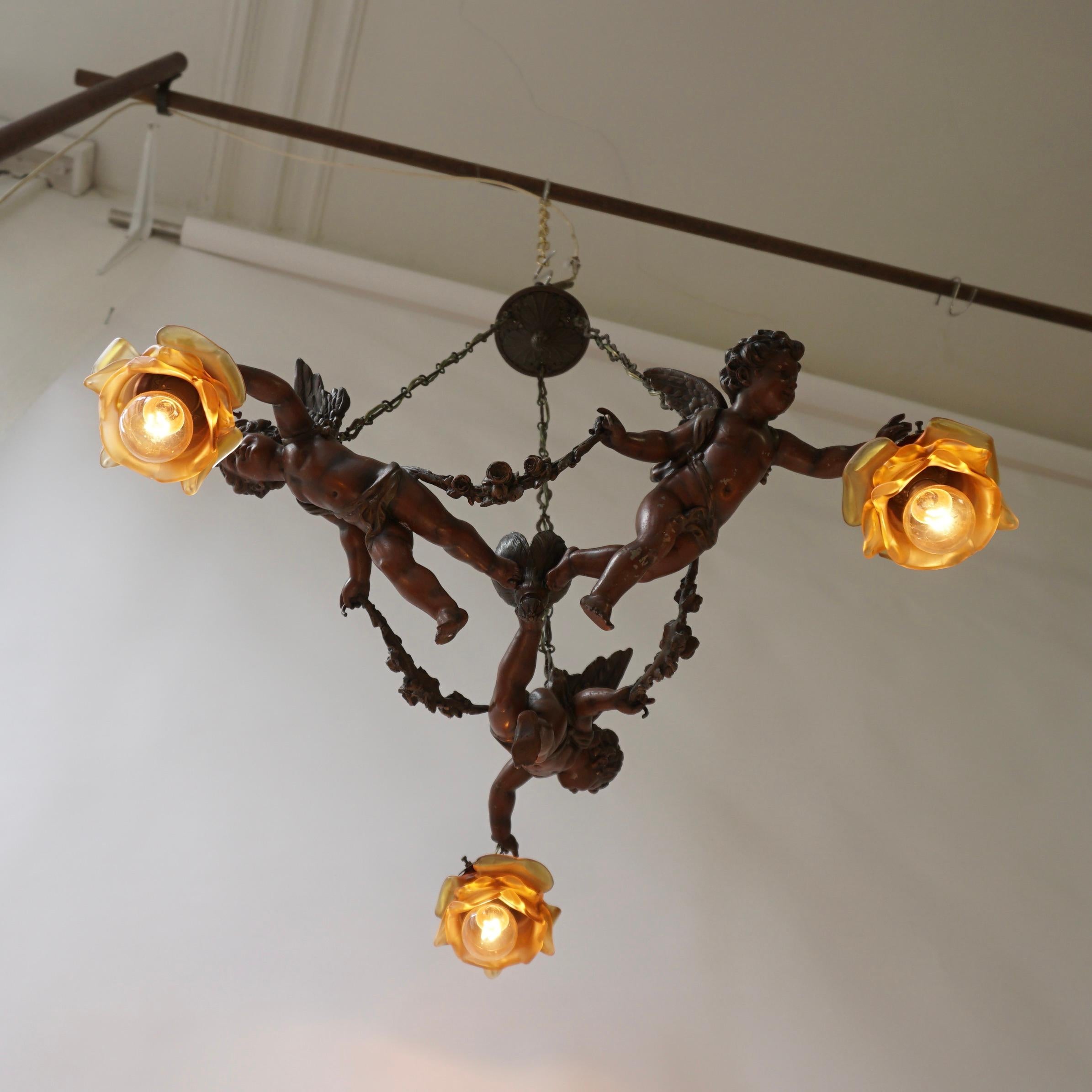 Metal French Chandelier with Three Cherubs Holding the Lights For Sale