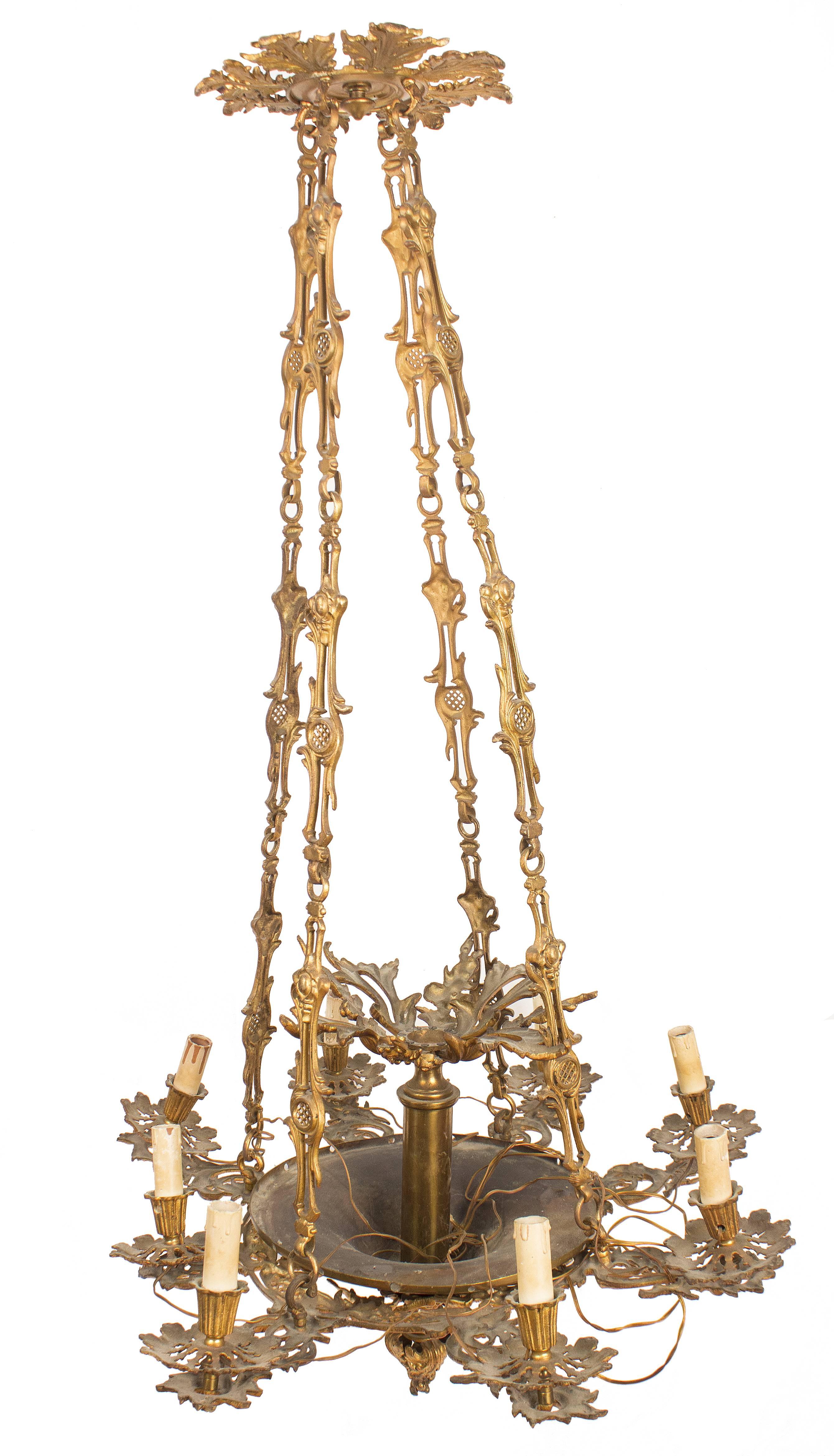 An ormolu pendant chandelier with eight candle holder arms decorated with neorococò foliage and terminating with small plate and acanthus leaves accompanied by small fluted bulb-shaped candle holder bowl. The central element is shape as smooth bowl