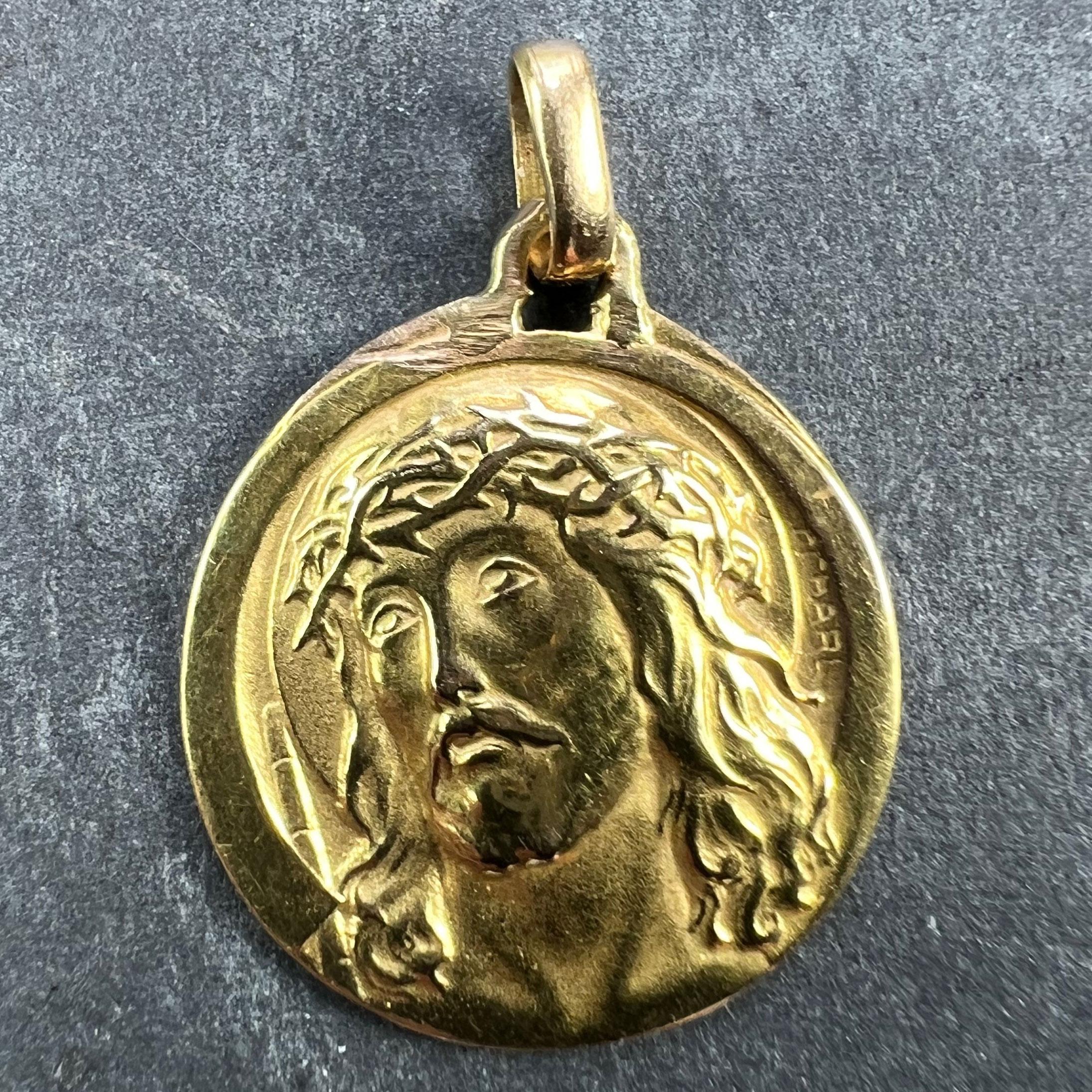 A French 18 karat (18K) yellow gold charm pendant designed as a round medal depicting Jesus Christ wearing the Crown of Thorns. Signed Charl, not stamped but tested as 18 karat gold.

Dimensions: 2.1 x 1.8 x 0.17 cm (not including jump ring)
Weight: