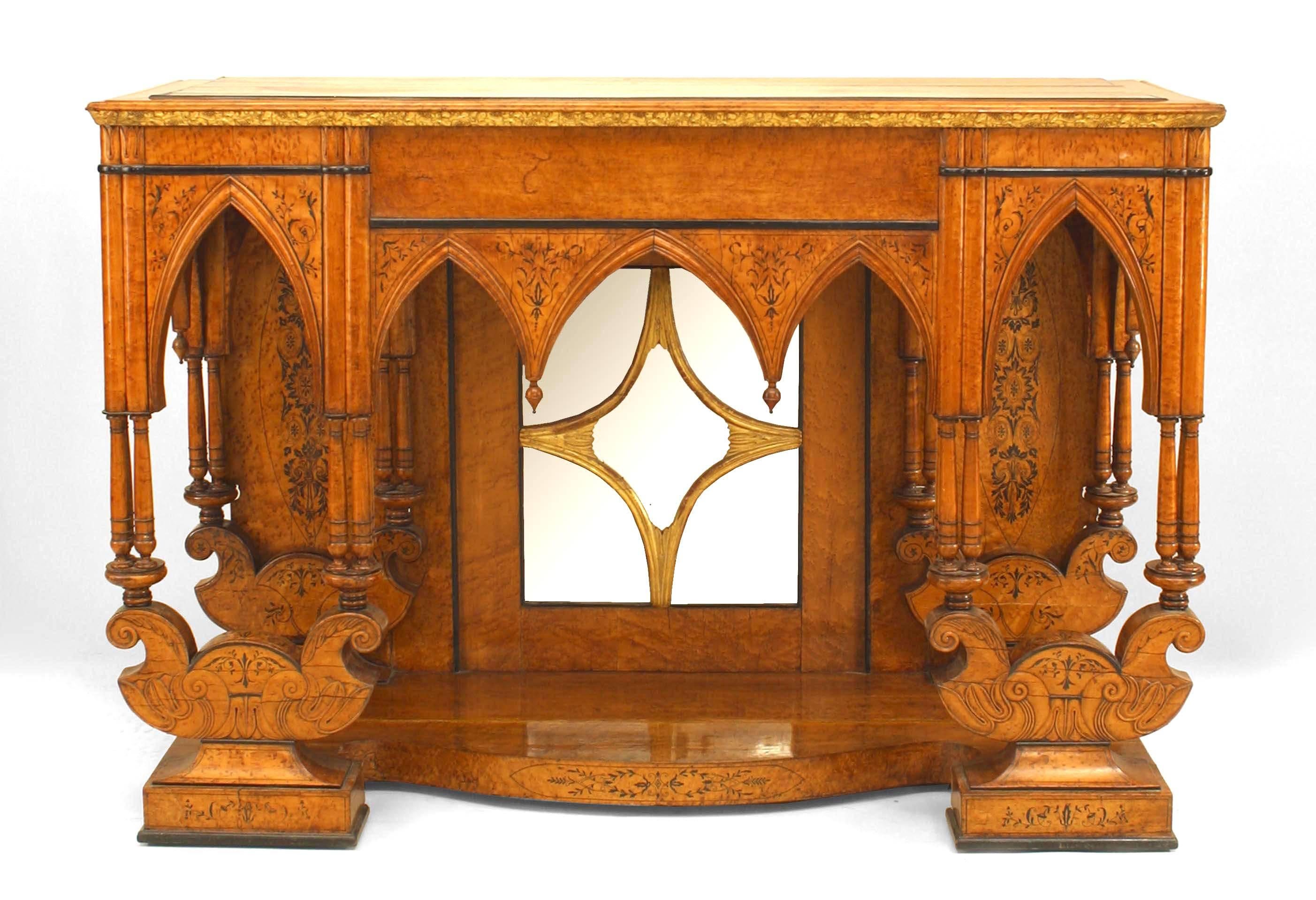French Charles X birds eye maple and ebonized trim and inlaid Gothic design console table with platform base and mirrored back with gilt floral carved edge on top.
 