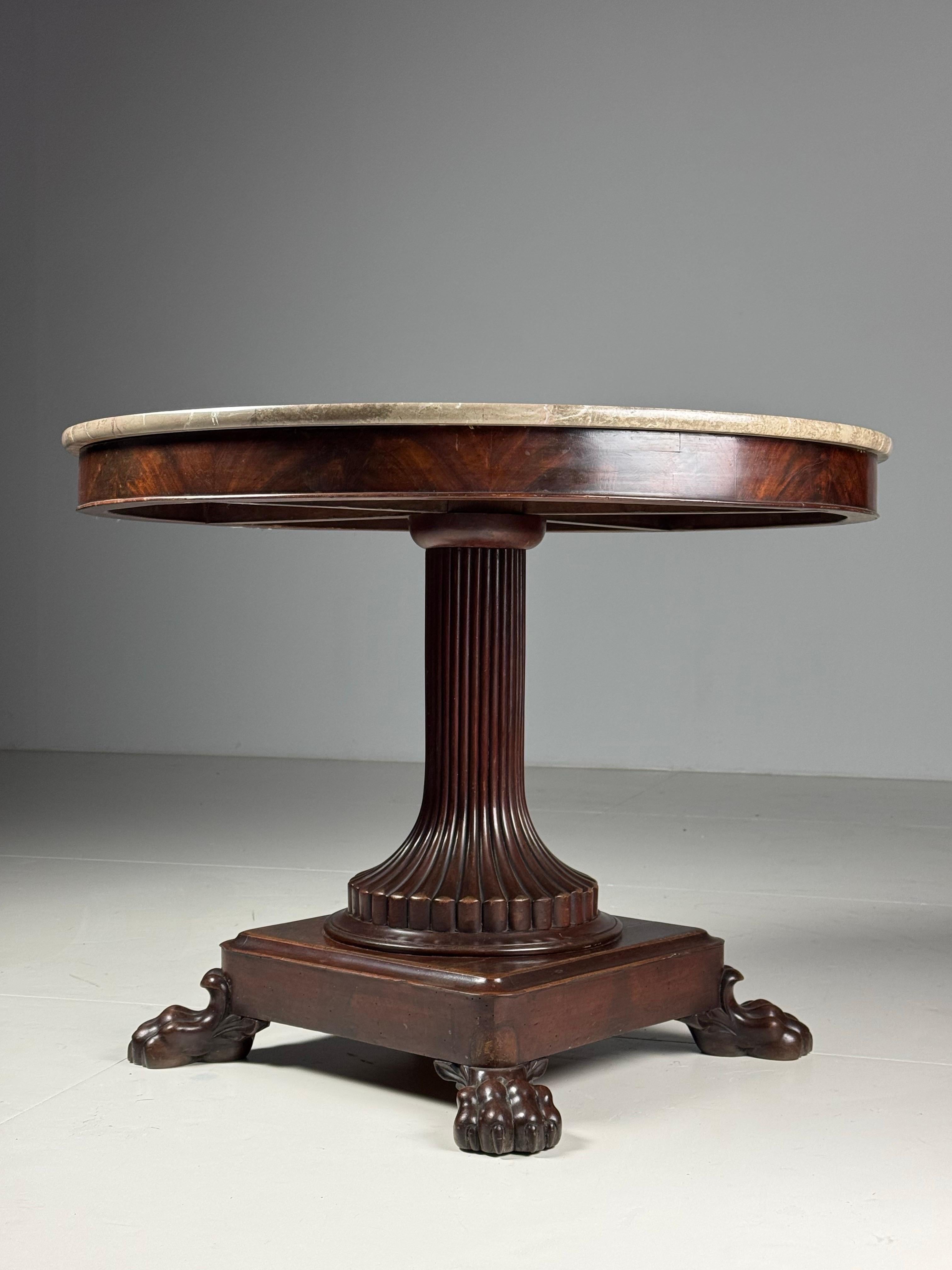 Originally from France, early 19th century. Oak base with mahogany veneer.

Fluted base standing on a square base. With 4 claw feet carved from mahogany.

Dimensions: 98ø x 74H