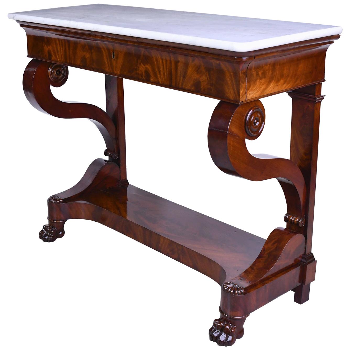 A very handsome French Empire or Charles X console in fine West Indies mahogany with original white marble top. Console has one long drawer along the apron, graceful 