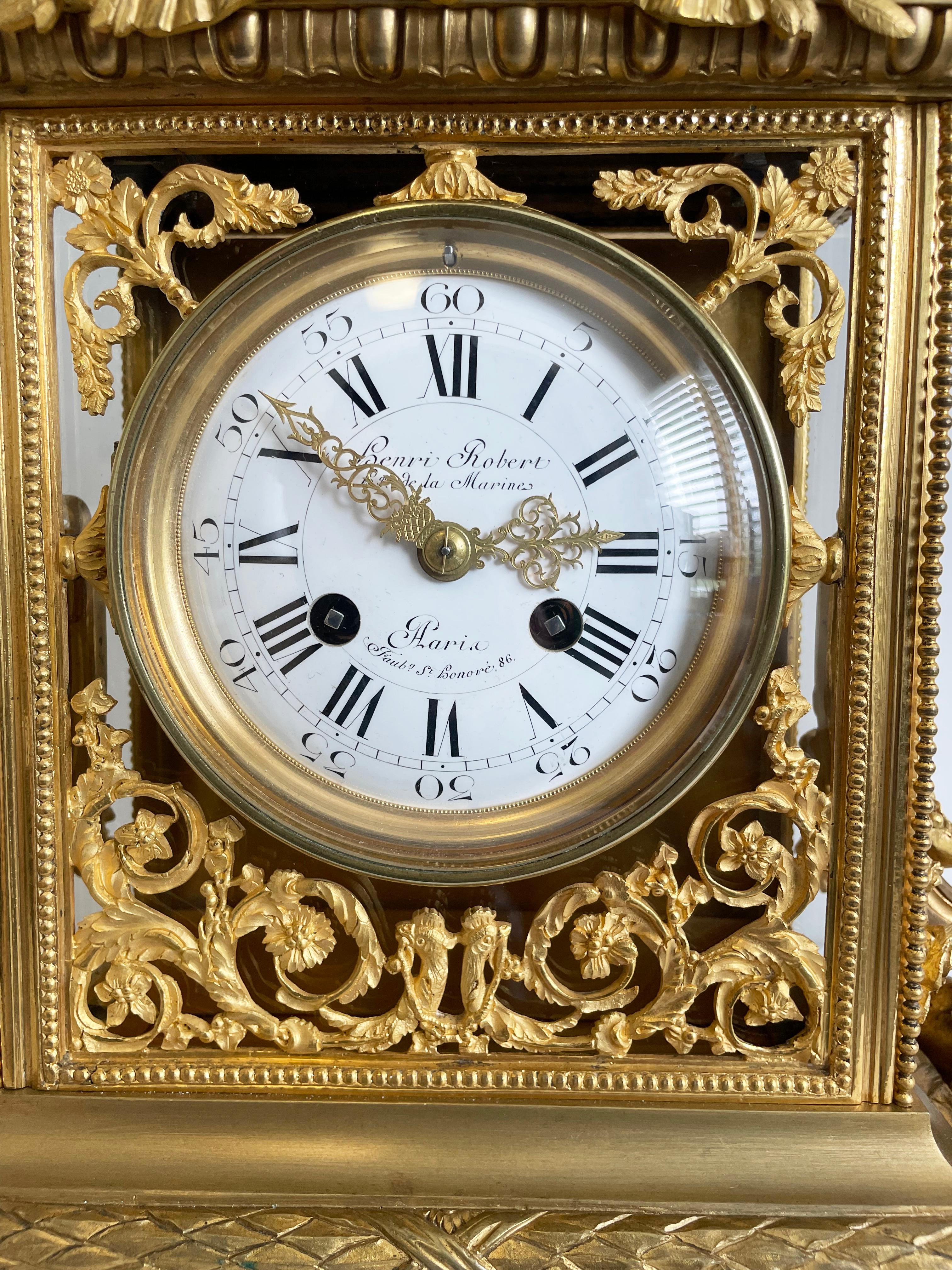 A French gilt bronze mantel clock by Henri Robert, circa 1880.

The decorative case with bevelled glass inserts, decorative floral swags and surmounted by a floral draped urn.

The ceramic dial with Roman numerals inscribed 'Henri Robert Hgr. de la