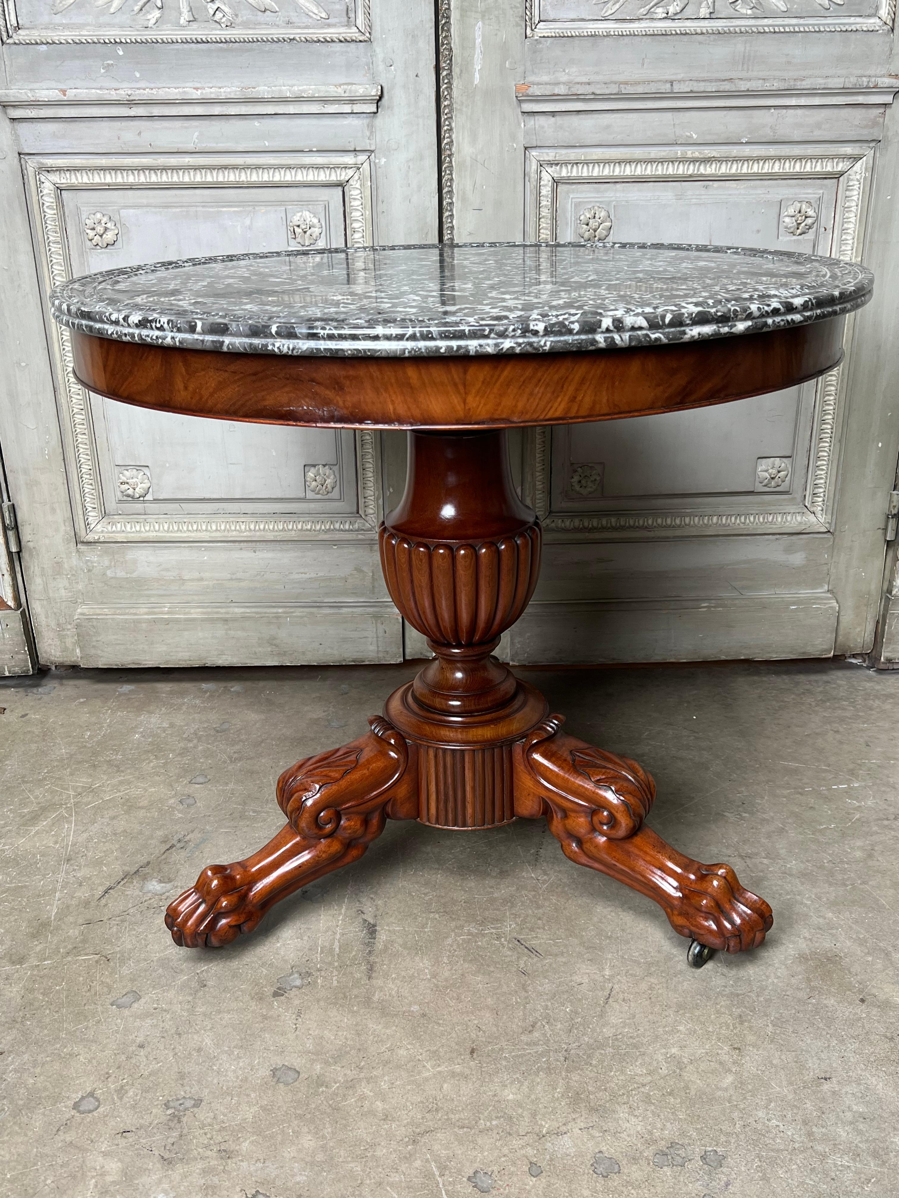 A French Charles X gueridon center table in mahogany with a marble top.
This beautiful table is a great size and could be used next to a sofa or bed or between a pair of chairs.  It has great deep carving and patina.  It has oak as its secondary