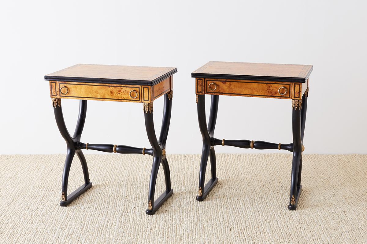 Magnificent pair of French Charles X restoration style maple tables or nightstands. These neoclassical tables have match veneered maple burl tops accented with a Greek key motif and a reeded edge. The case is supported by Curule style legs with an