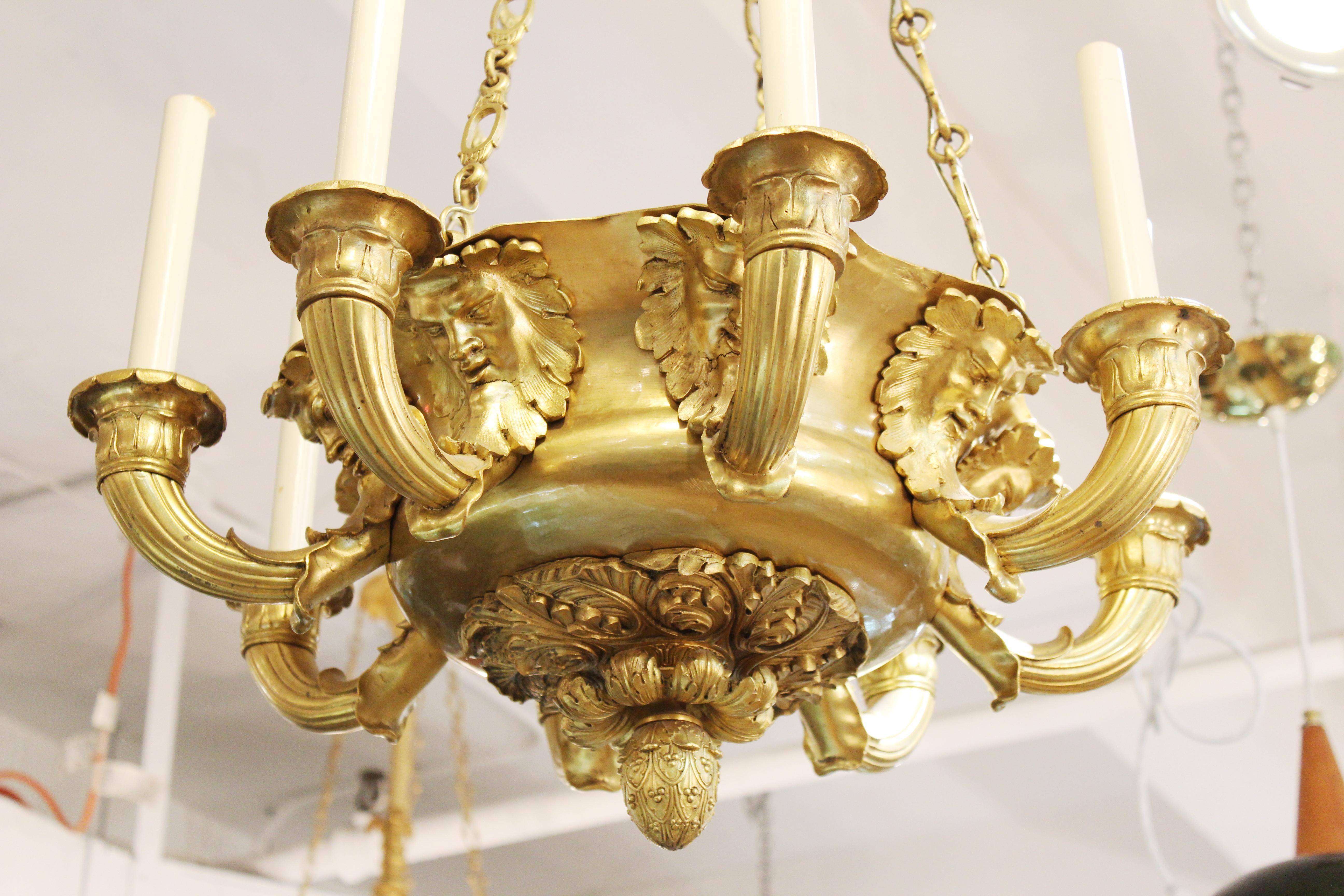 French Charles X gilt bronze eight-arm chandelier with mascaron (mask / masque) figures. Measures: 34