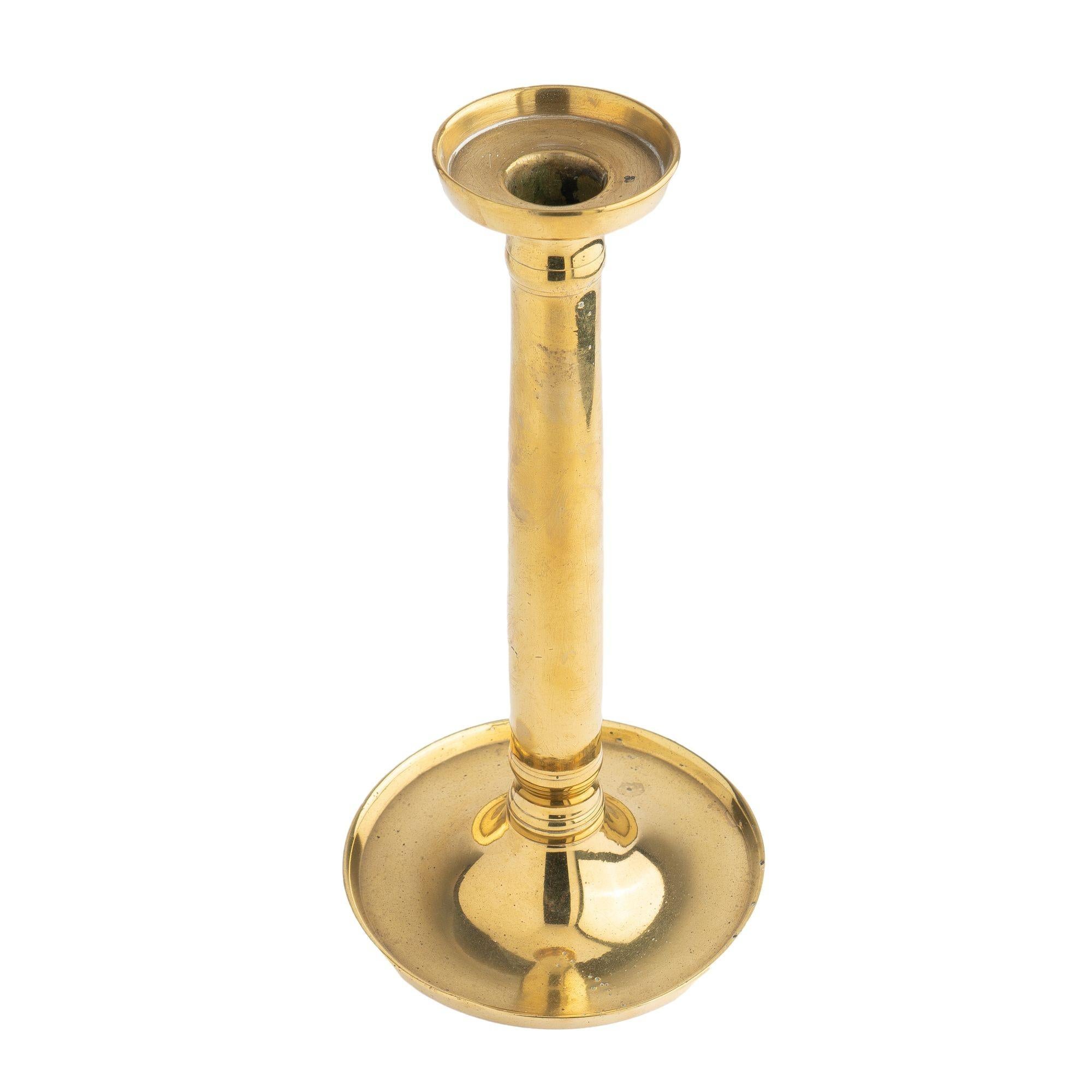 Cast brass columnar candlestick with standing rim bobeshe and circular standing rim base. Seam cast and threaded shaft to base.

France, Restoration period, circa 1815-30.