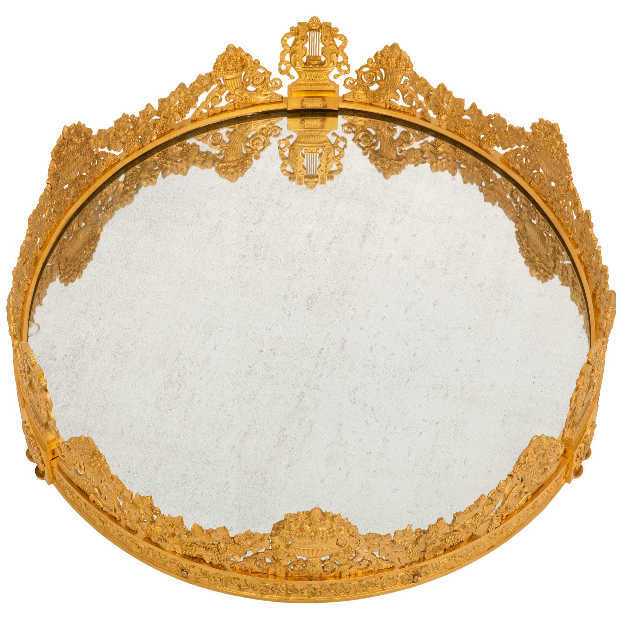 A most impressive and large scale French 19th century Charles X Period Ormolu and Mirror centerpiece plateau, signed Dunouy Fait a Paris. The Sur Tout de Table is raised by three double demi lune Ormolu supports below blocks which are decorated by
