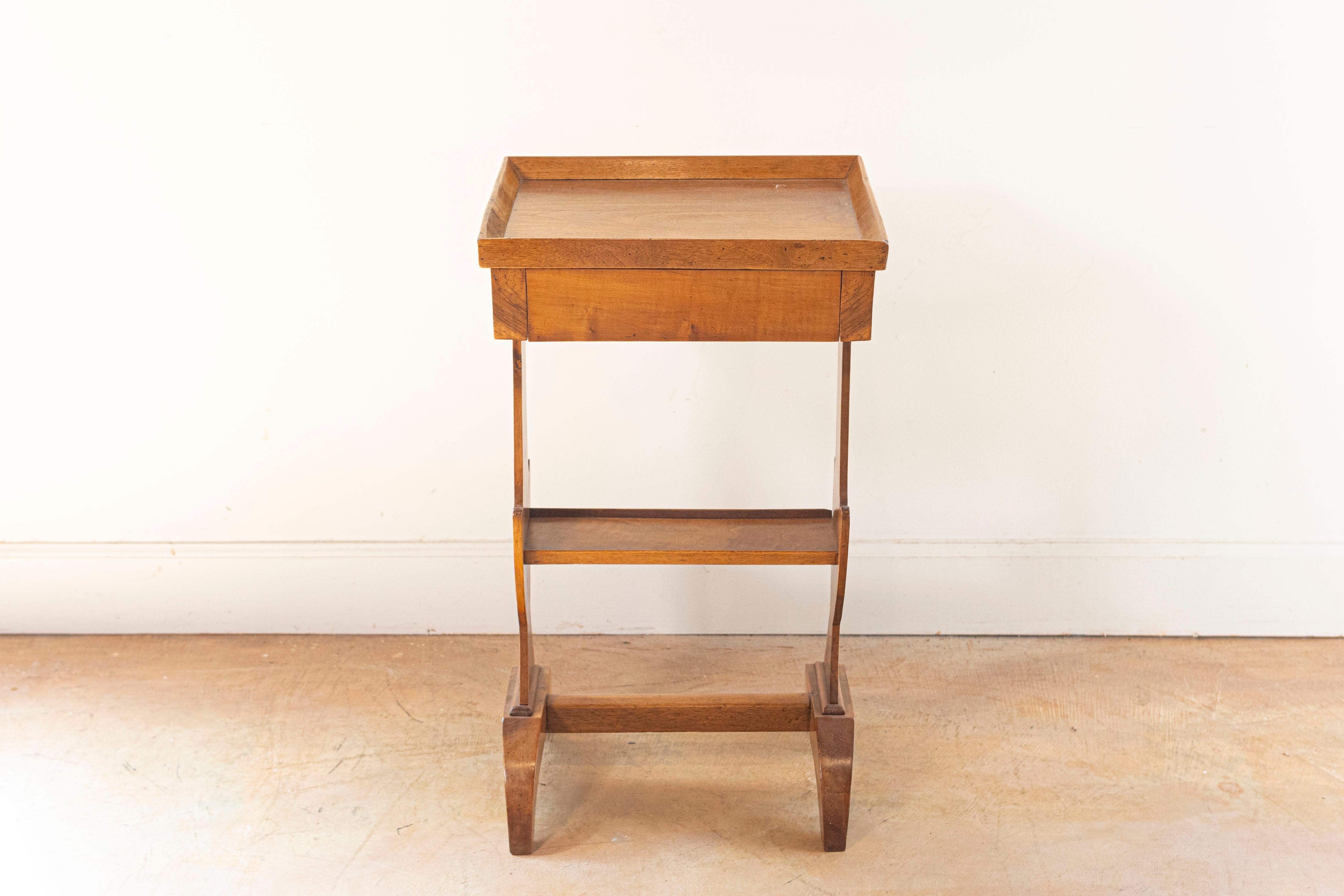 Table d'appoint en noyer d'époque Charles X, vers 1830, avec plateau, un seul tiroir et une base élancée en tréteaux composée de pieds sculptés et d'une traverse. Plongez dans l'allure de l'élégance française du début du XIXe siècle avec cette table