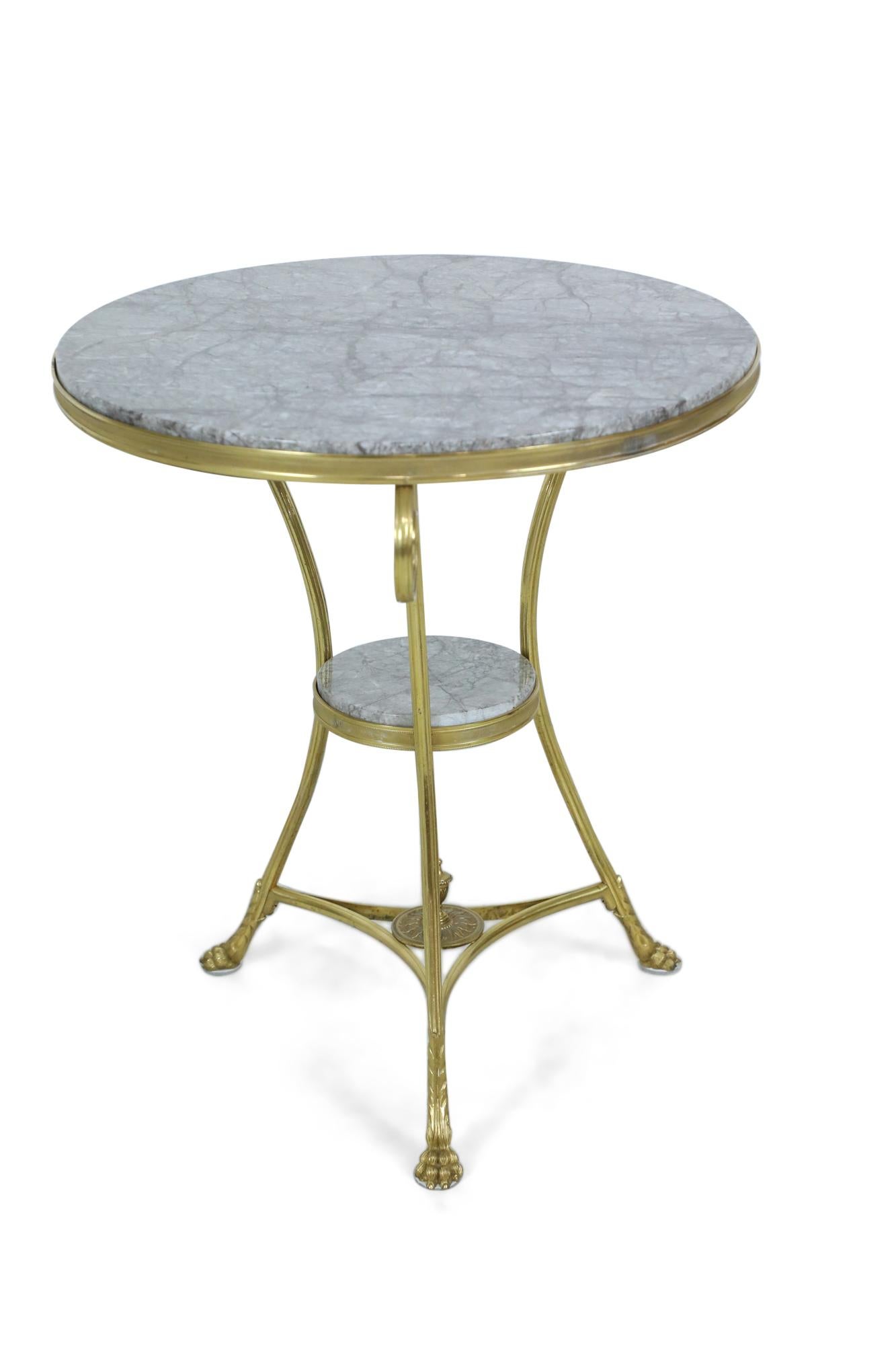 French Charles X-style bronze gueridon / side table with a grey circular inset marble top and shelf and a bottom stretcher with decorative finial connecting 3 scroll legs ending in hoof shaped feet.